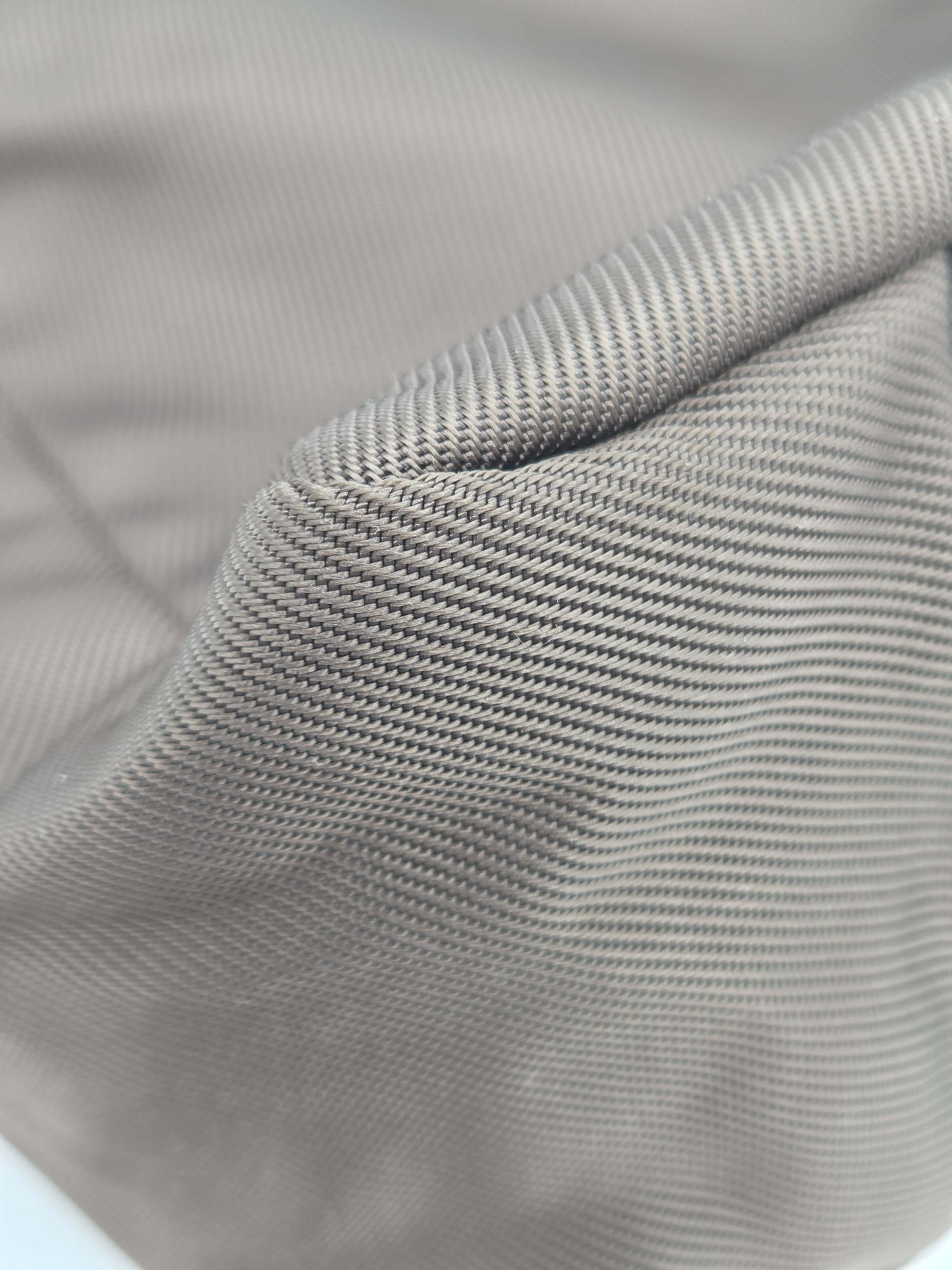 Close-up of a light gray ribbed fabric texture with a folded corner showing the woven material detail.