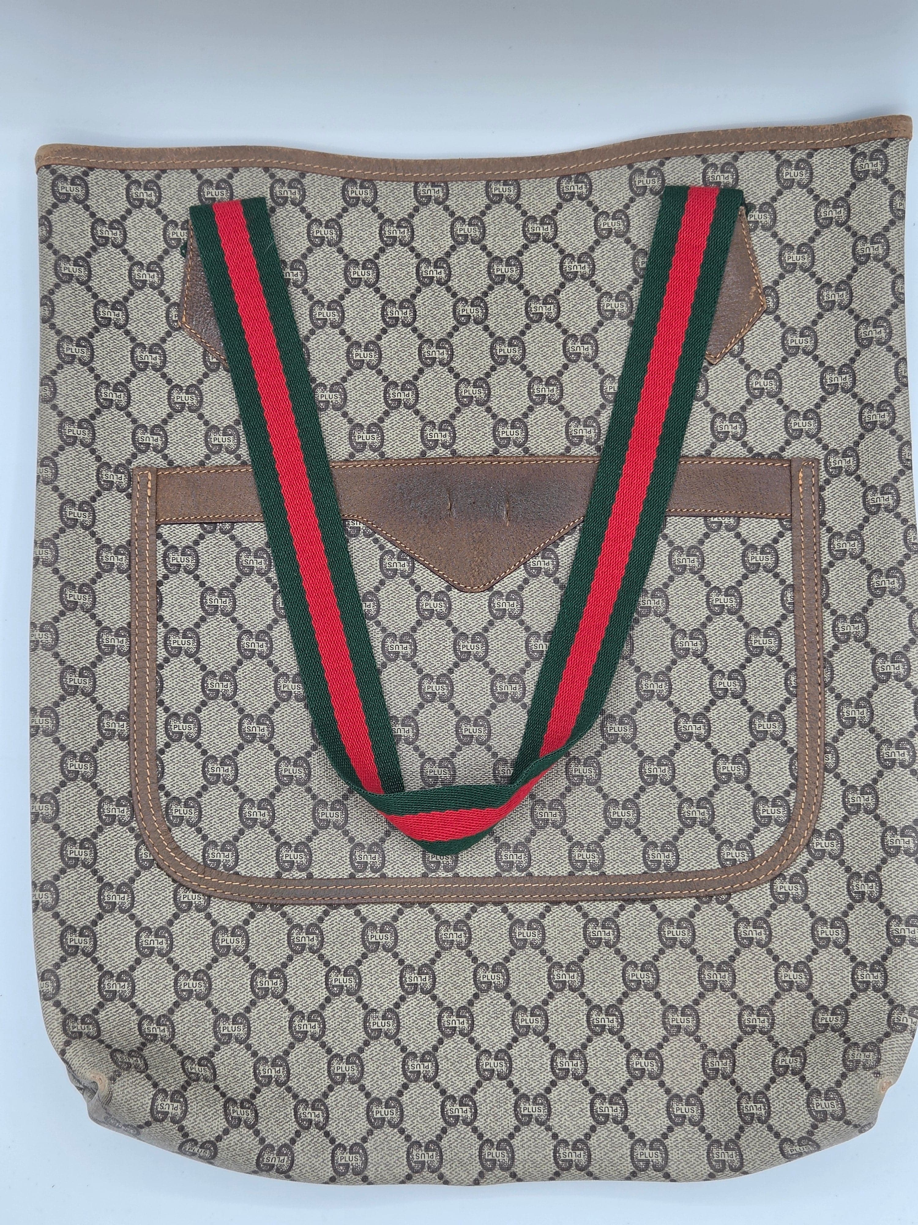 A vintage Gucci shoulder bag in the classic GG Supreme canvas, featuring a brown leather trim and signature green and red web stripe handles.