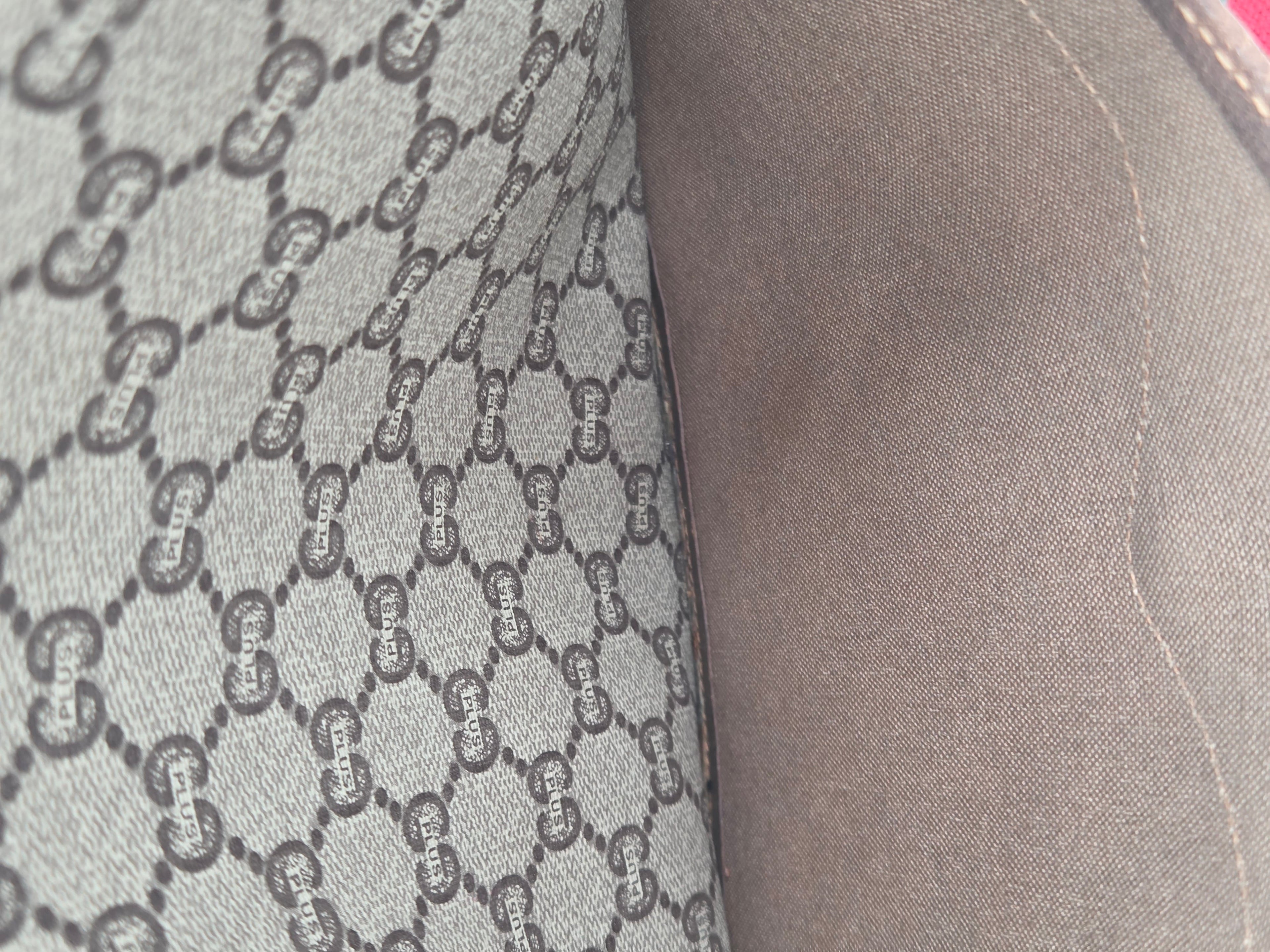 Close-up of a gray fabric surface with a repeating interlocking G monogram pattern and a smooth gray side panel.
