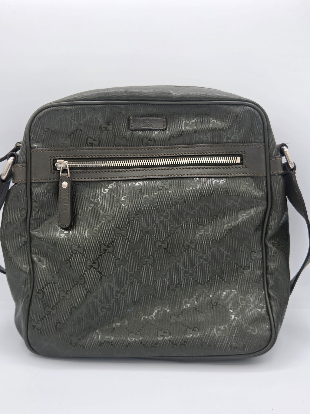 A dark gray Gucci backpack with the brand's signature GG monogram pattern, featuring a vertical zippered pocket on the front and a top handle, shown against a plain white background.