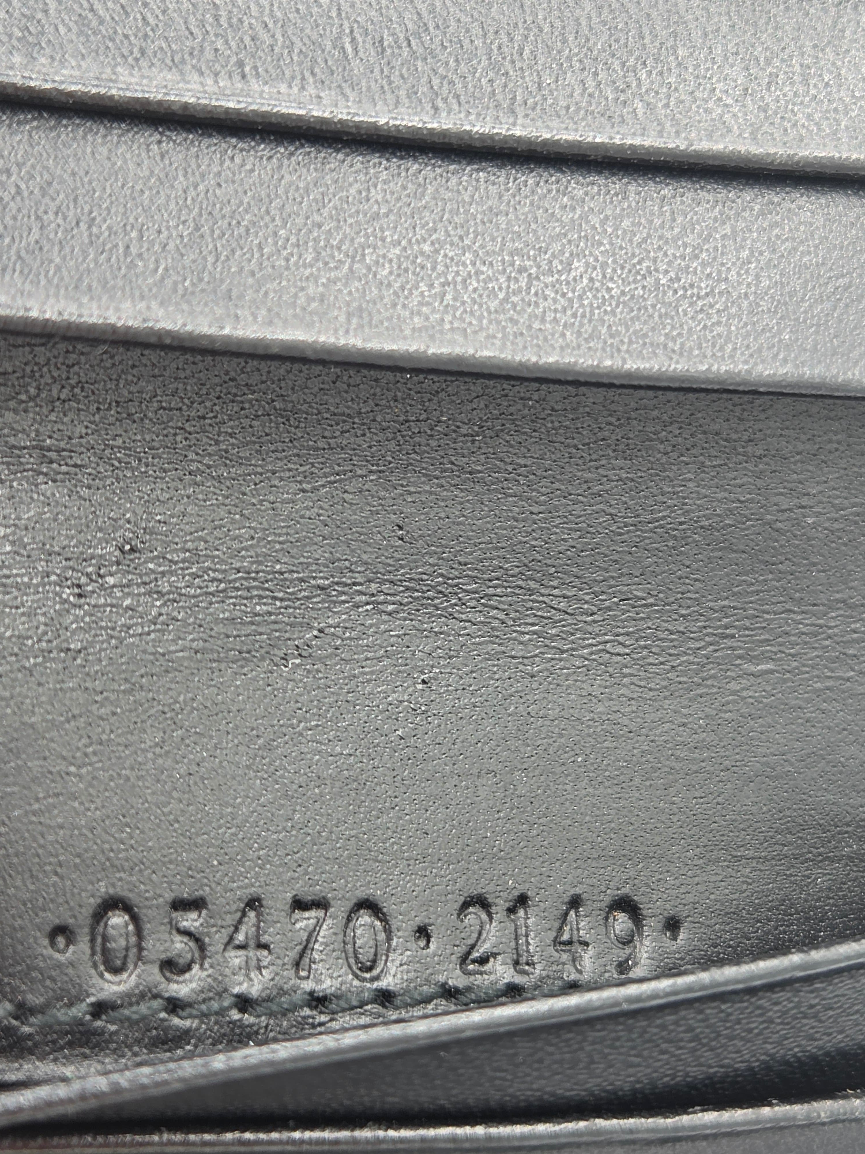 Close-up of a dark gray textured material with embossed vertical ridges and a stamped numeric marking reading 05470-2149.