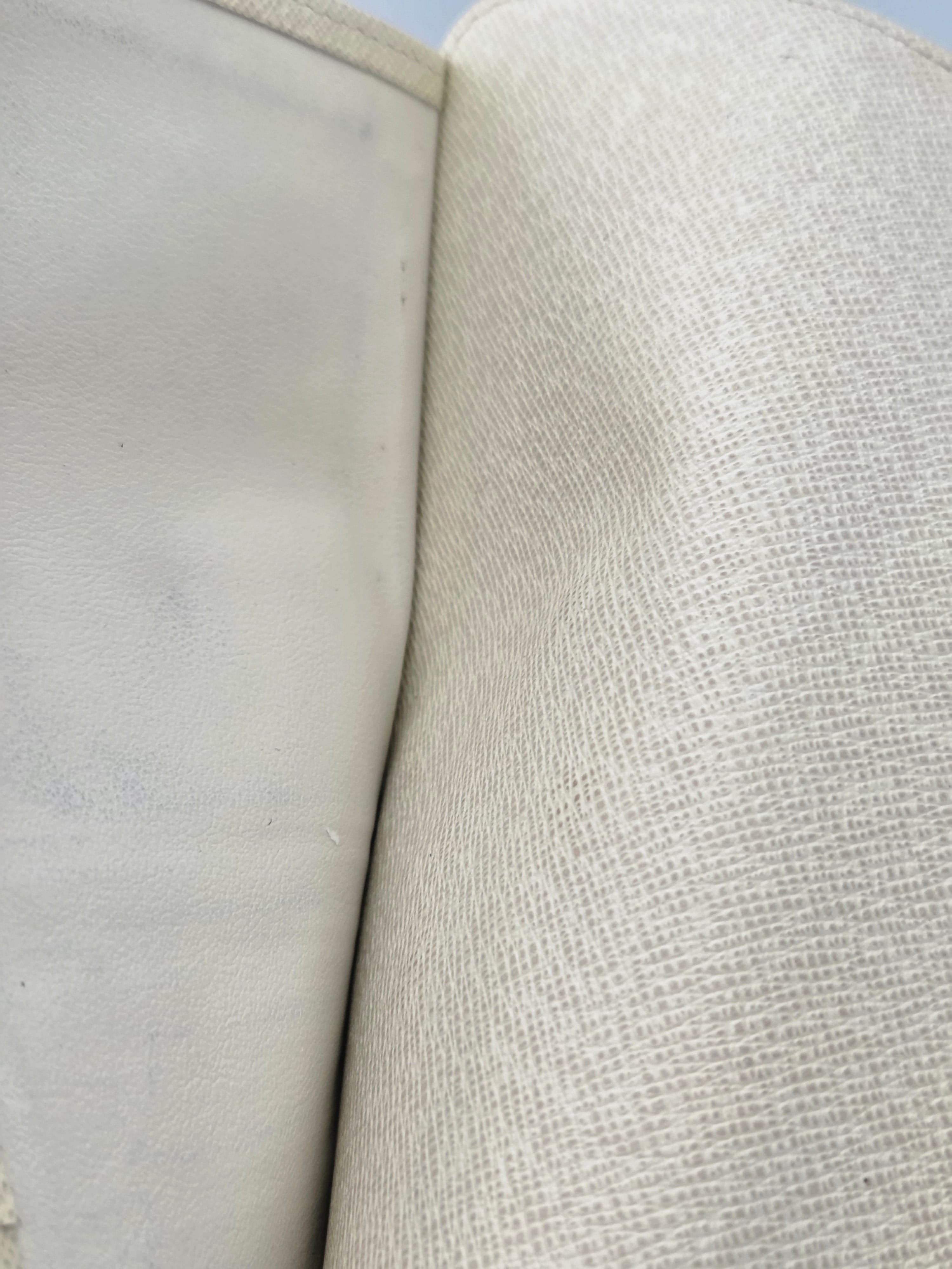 Close-up of a light beige woven fabric with a textured surface and a smooth, slightly stained off-white interior lining.