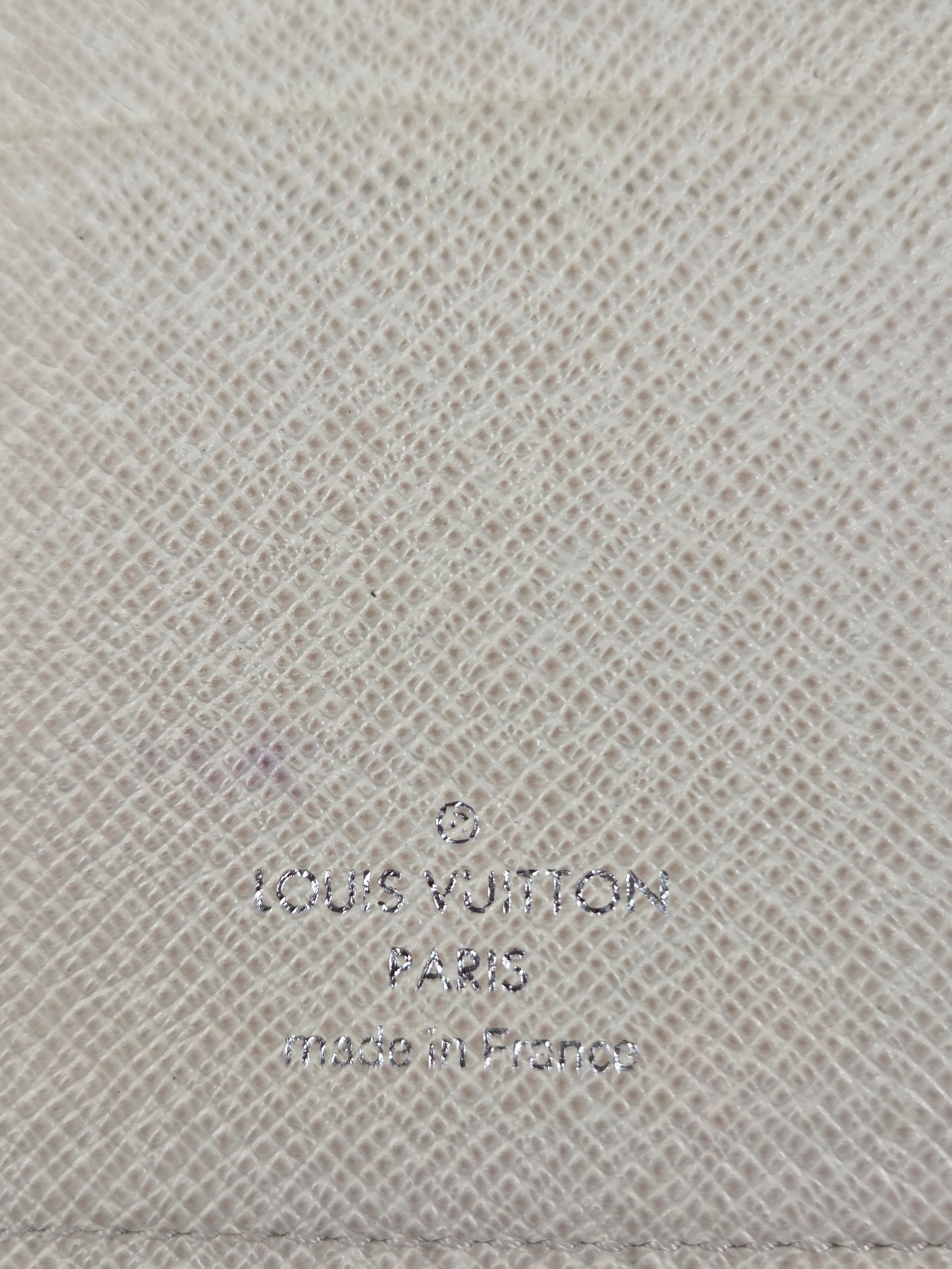 Close-up of a light beige woven fabric texture with faint embossed or printed Louis Vuitton text visible on the right side.
