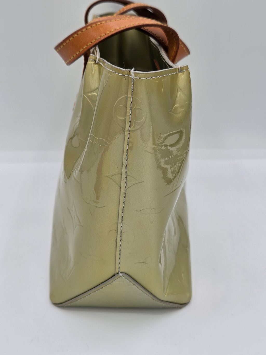 A Louis Vuitton shoulder bag in glossy olive green patent leather with an embossed monogram pattern and a brown leather strap, shown from a front-three-quarter angle on a white background.