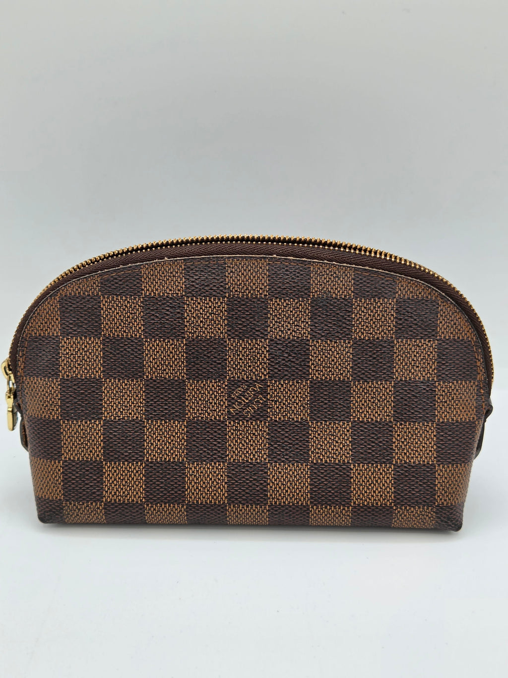 A Louis Vuitton zippered pouch in the Damier Ebene checkered canvas, featuring alternating brown and tan squares with a gold-tone zipper.