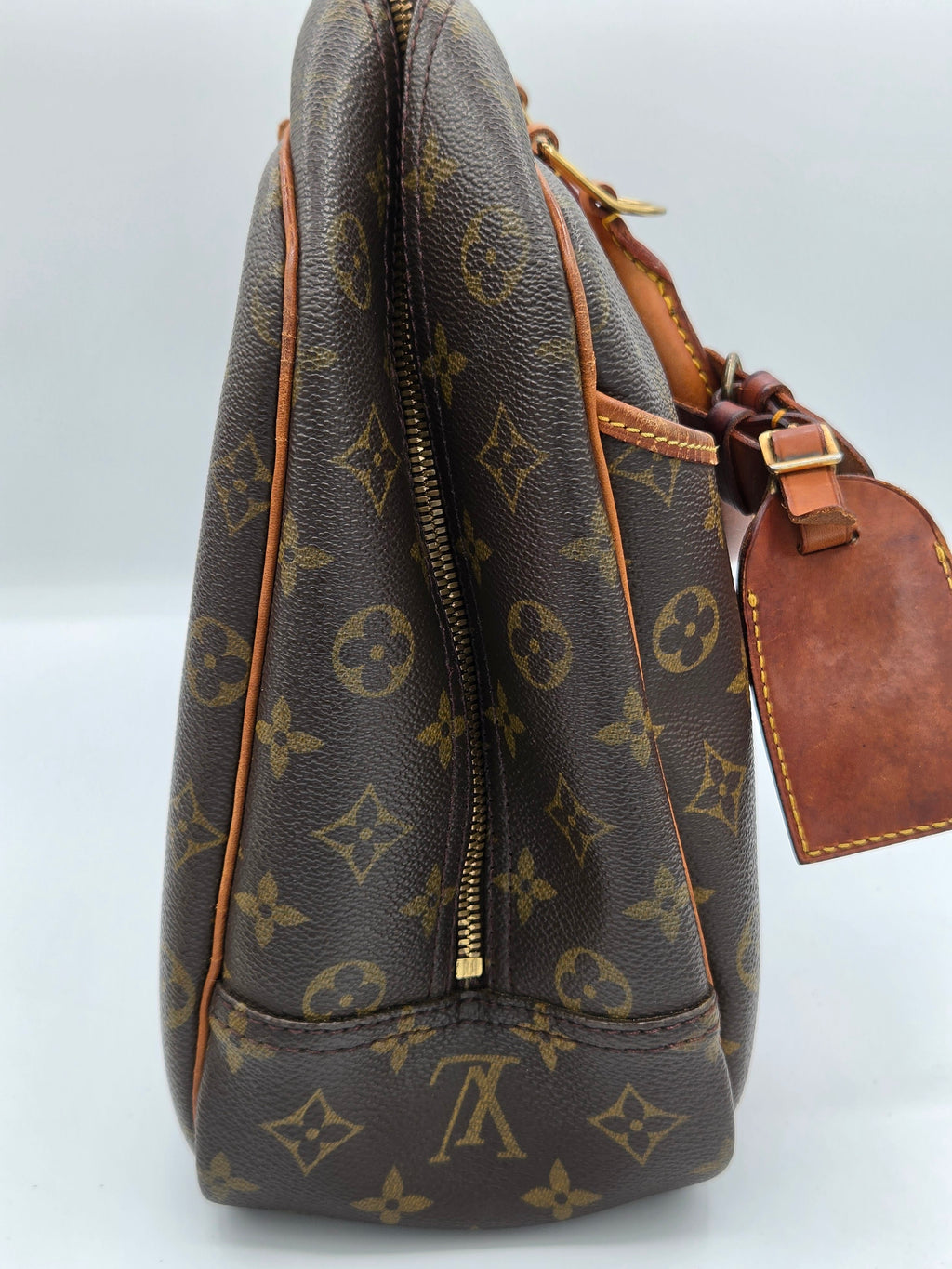 Louis Vuitton monogram canvas shoulder bag in dark brown with tan leather trim and a gold-tone zipper, shown against a plain white background.