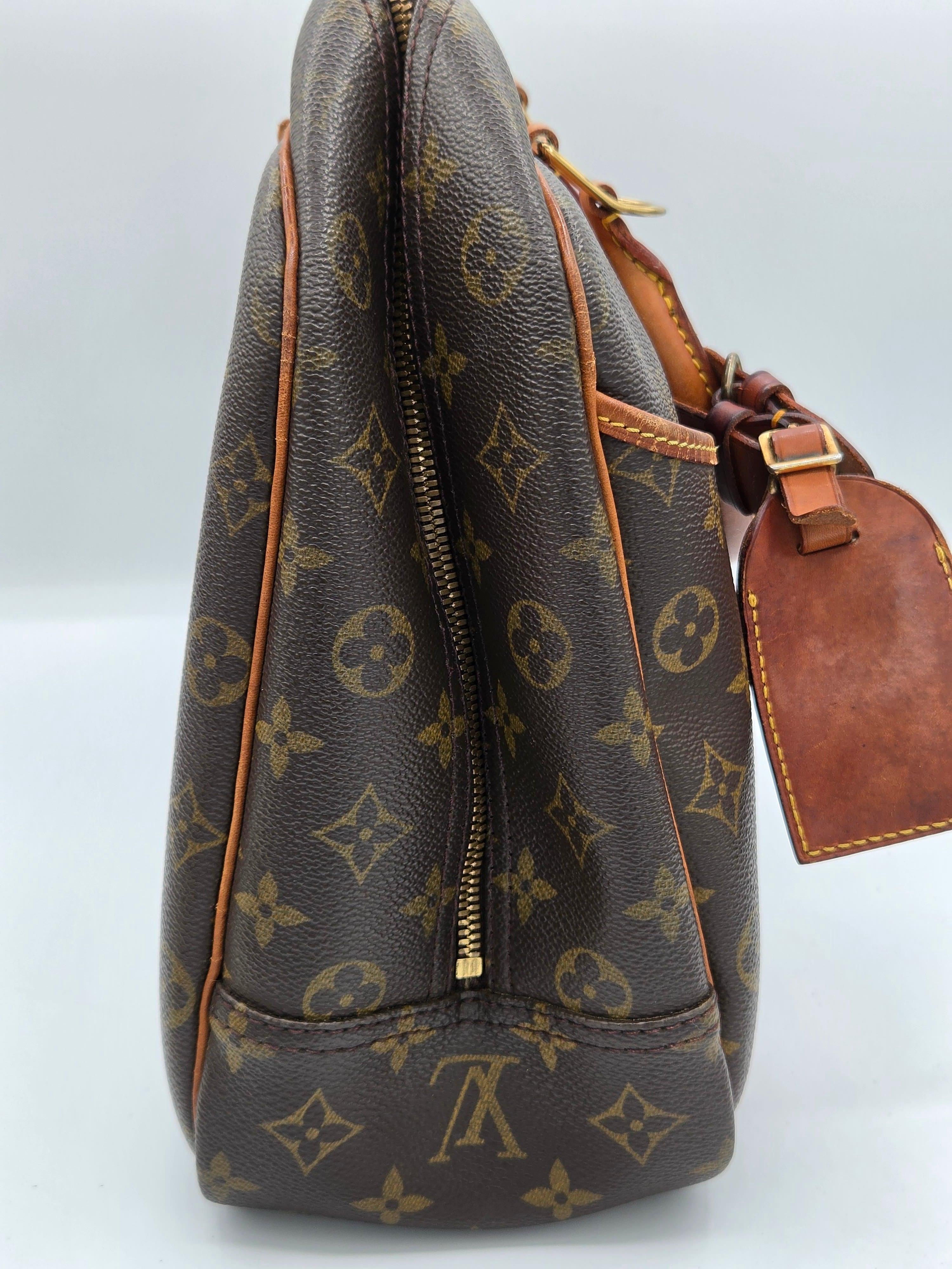 Louis Vuitton monogram canvas shoulder bag in dark brown with tan leather trim and a gold-tone zipper, shown against a plain white background.
