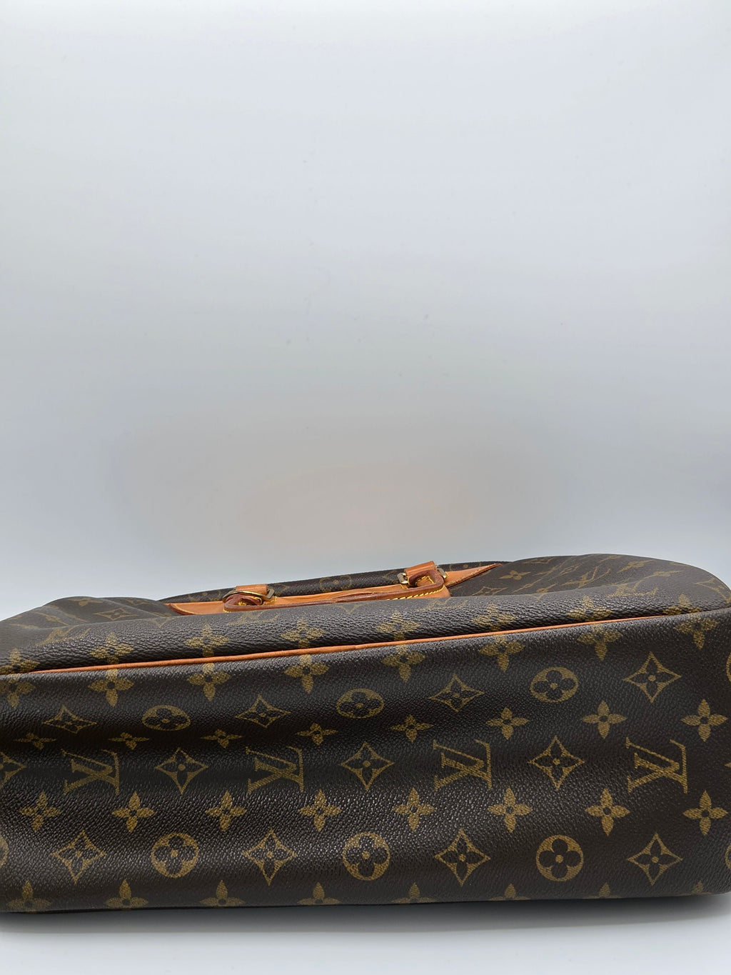 Louis Vuitton monogram canvas bag in brown and tan, shown cropped on the right side against a plain light gray background.