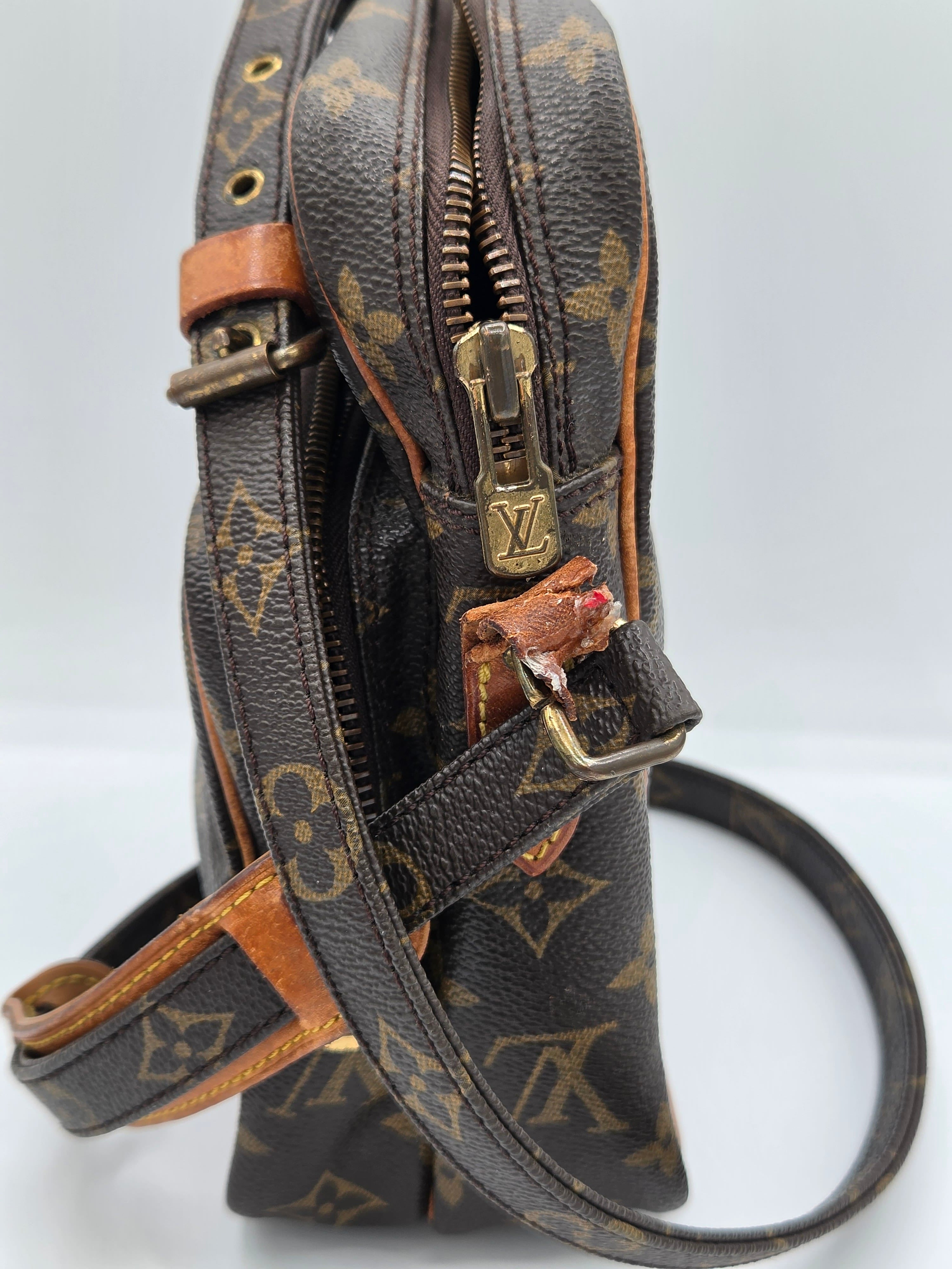 A close-up of a Louis Vuitton monogram shoulder bag in dark brown coated canvas with tan leather trim and gold-tone hardware, shown against a plain light background.