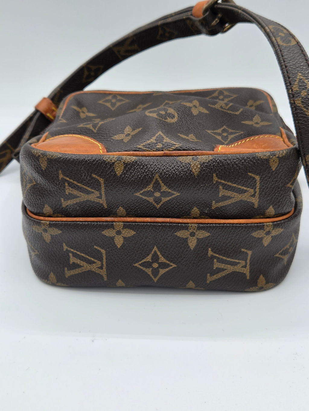 A Louis Vuitton monogram canvas shoulder bag shown from an angled side view against a plain white background.