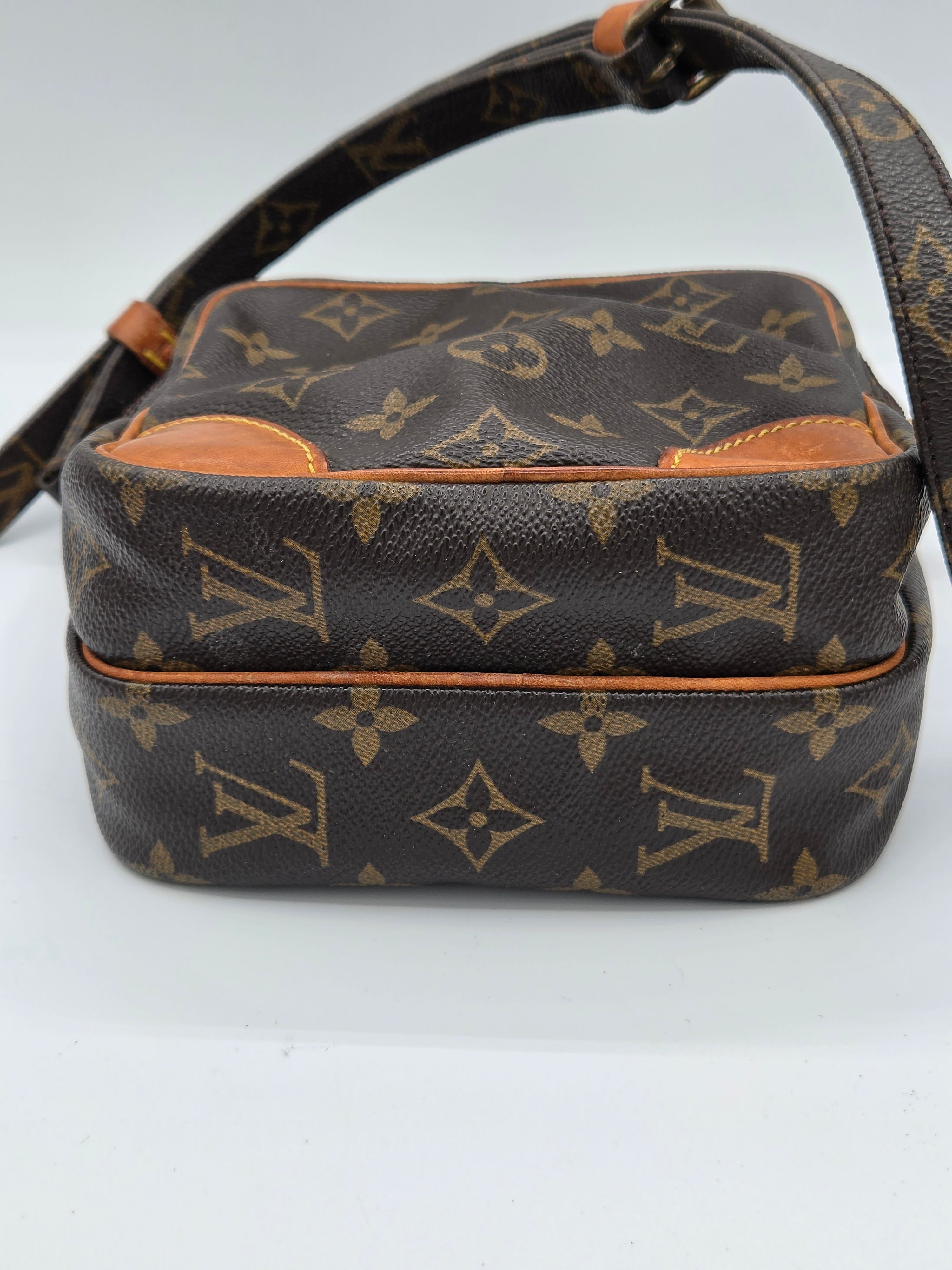 A Louis Vuitton monogram canvas shoulder bag shown from an angled side view against a plain white background.