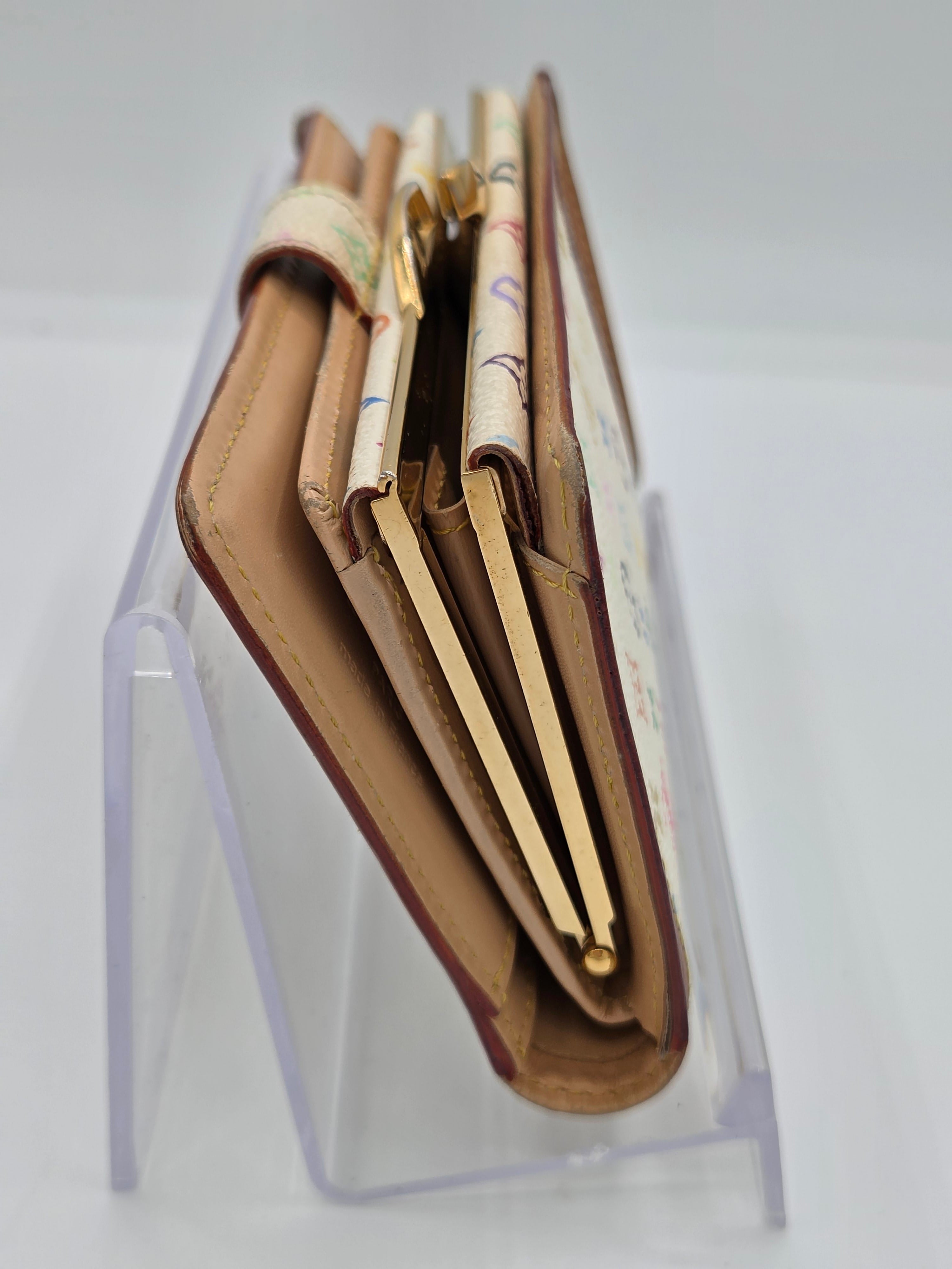 A brown leather wallet with gold-tone hardware and patterned paper inserts, displayed on a clear acrylic stand against a white background.