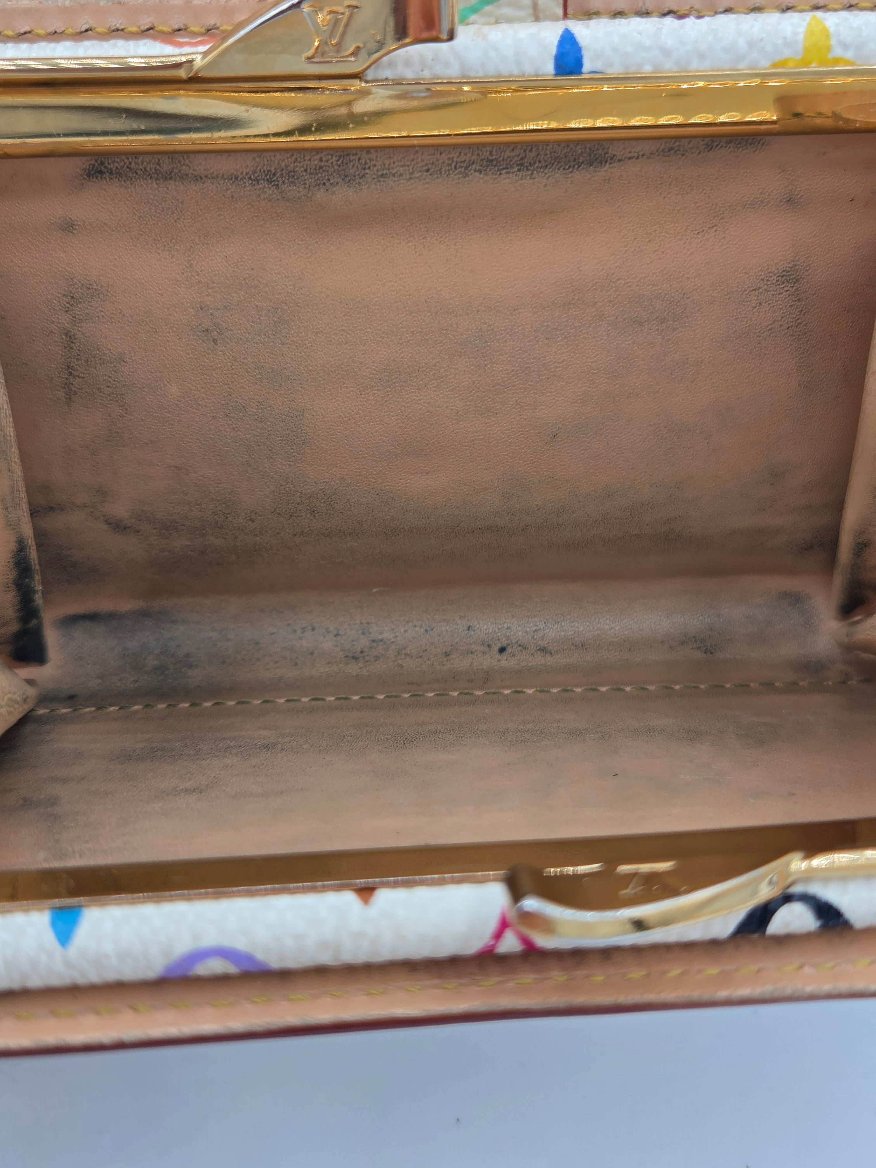 Close-up of the interior of a Louis Vuitton handbag, showing the brown leather lining, gold-tone metal frame, and a portion of the signature multicolor printed canvas on the right side.