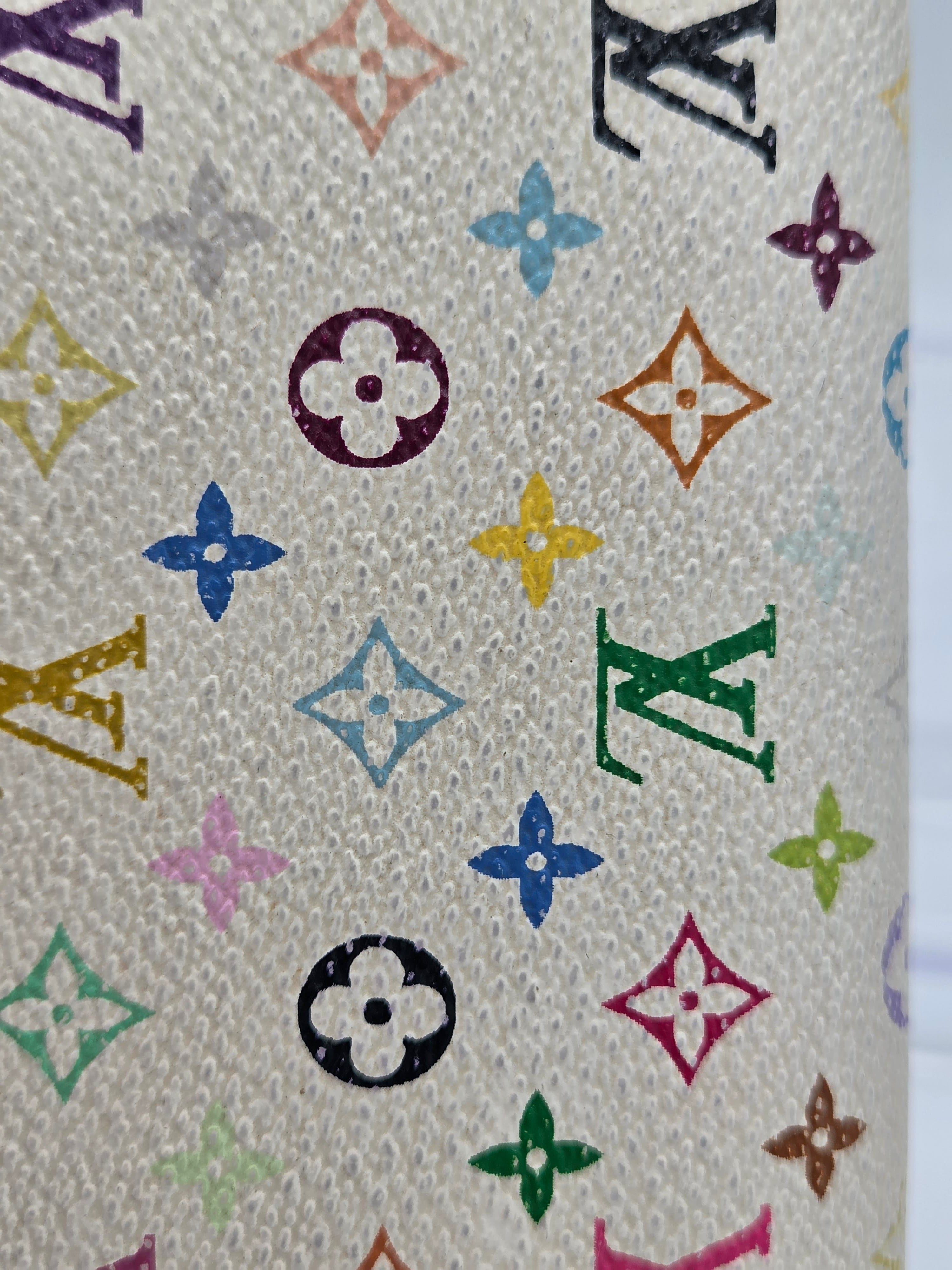 Close-up of a textured beige fabric featuring the classic Louis Vuitton monogram pattern in multiple colors, including green, blue, yellow, pink, orange, and purple.