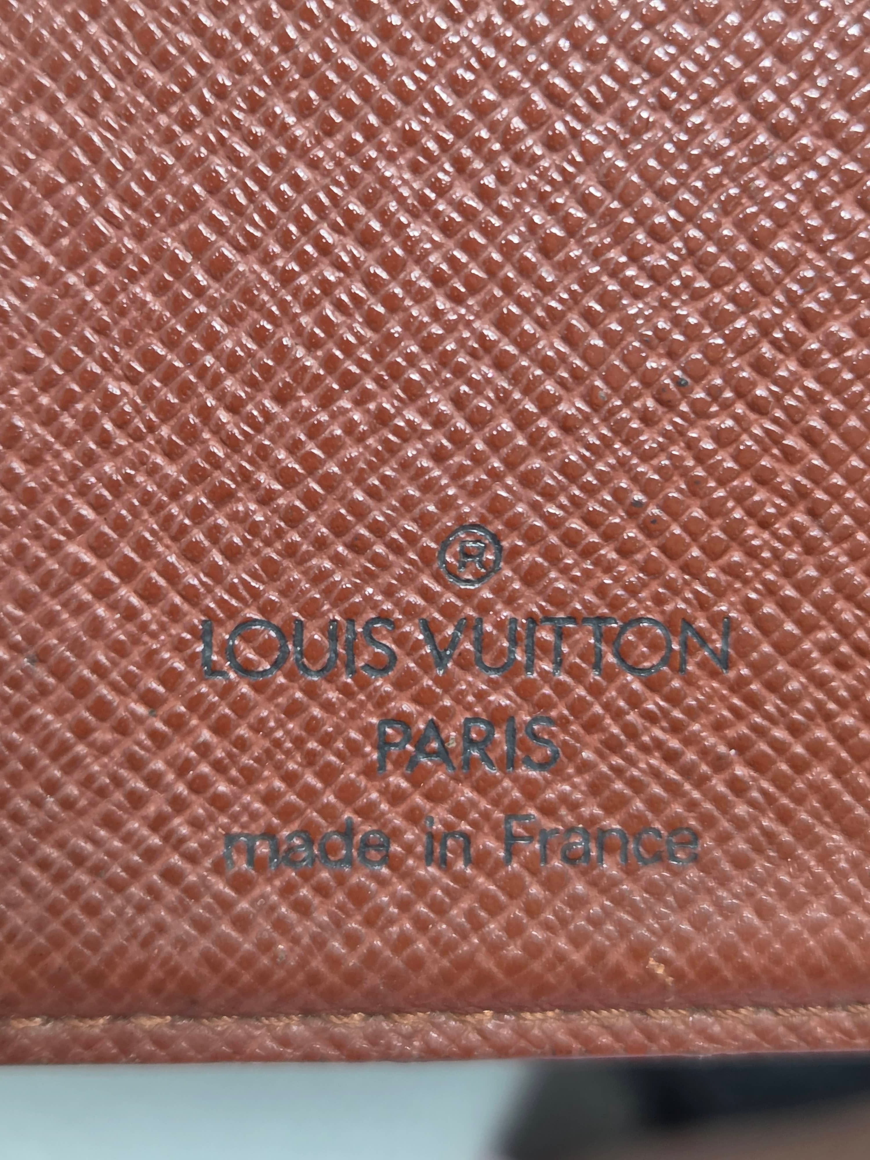 Close-up of a Louis Vuitton brown textured leather item, showing the embossed logo and 'Made in France' text.