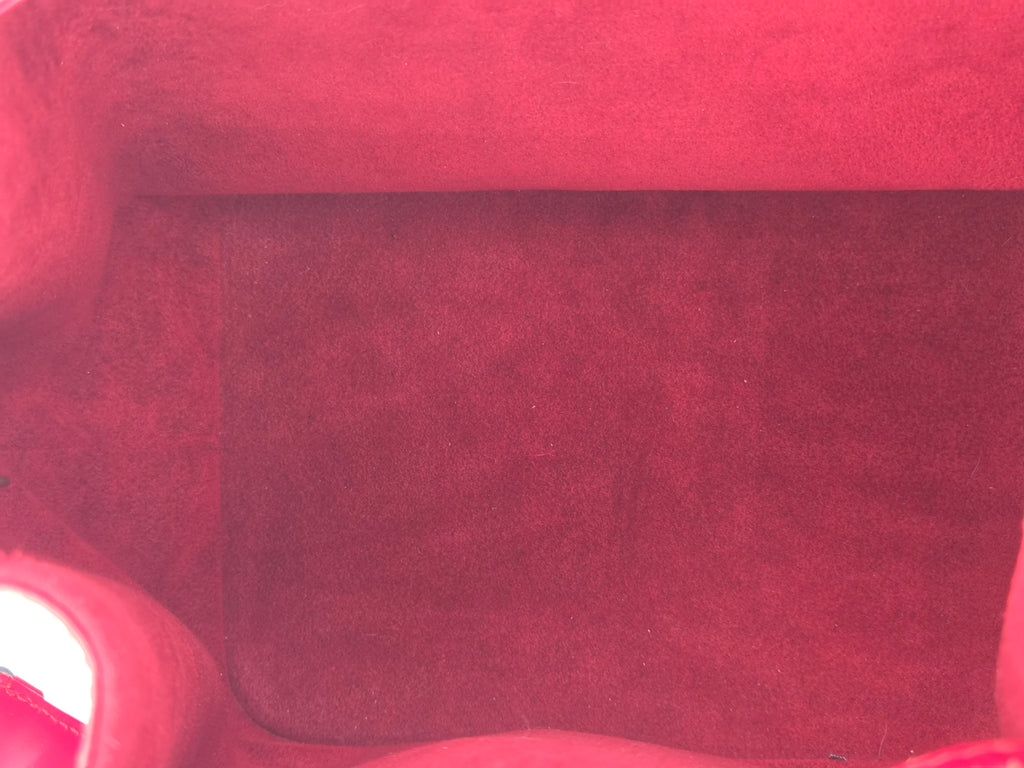 Close-up of a textured red fabric surface, likely a chair or upholstered furniture material.