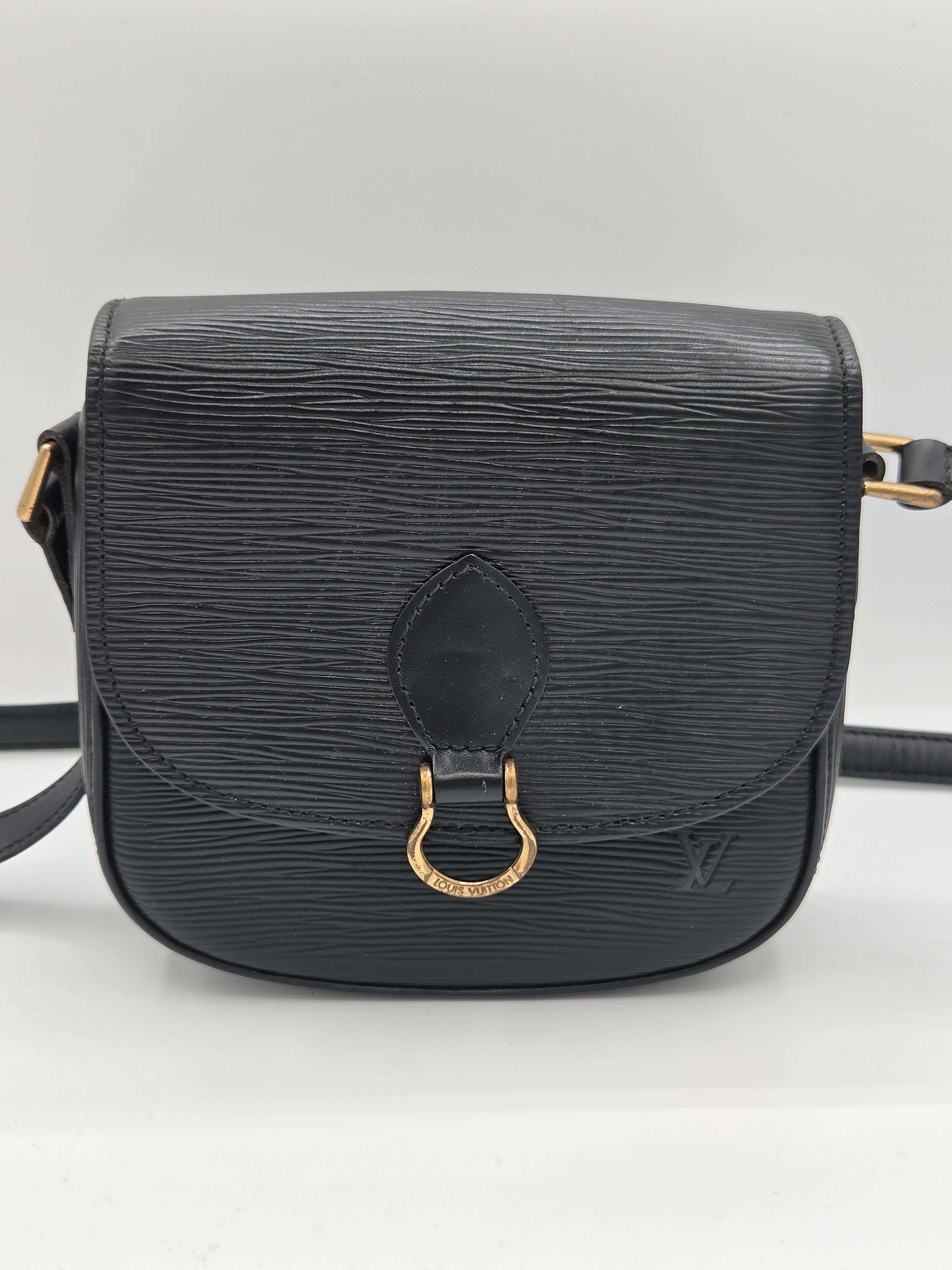 A black textured leather shoulder bag with a gold-tone horsebit hardware accent on the front flap, shown against a plain white background.