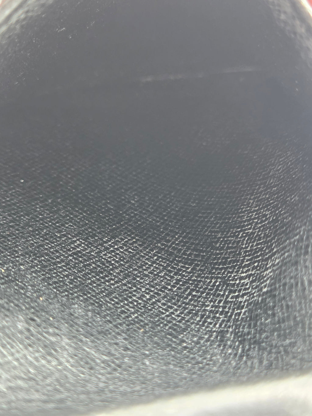 A close-up of a dark gray textured material, showing a fine woven or leather-like grain pattern.