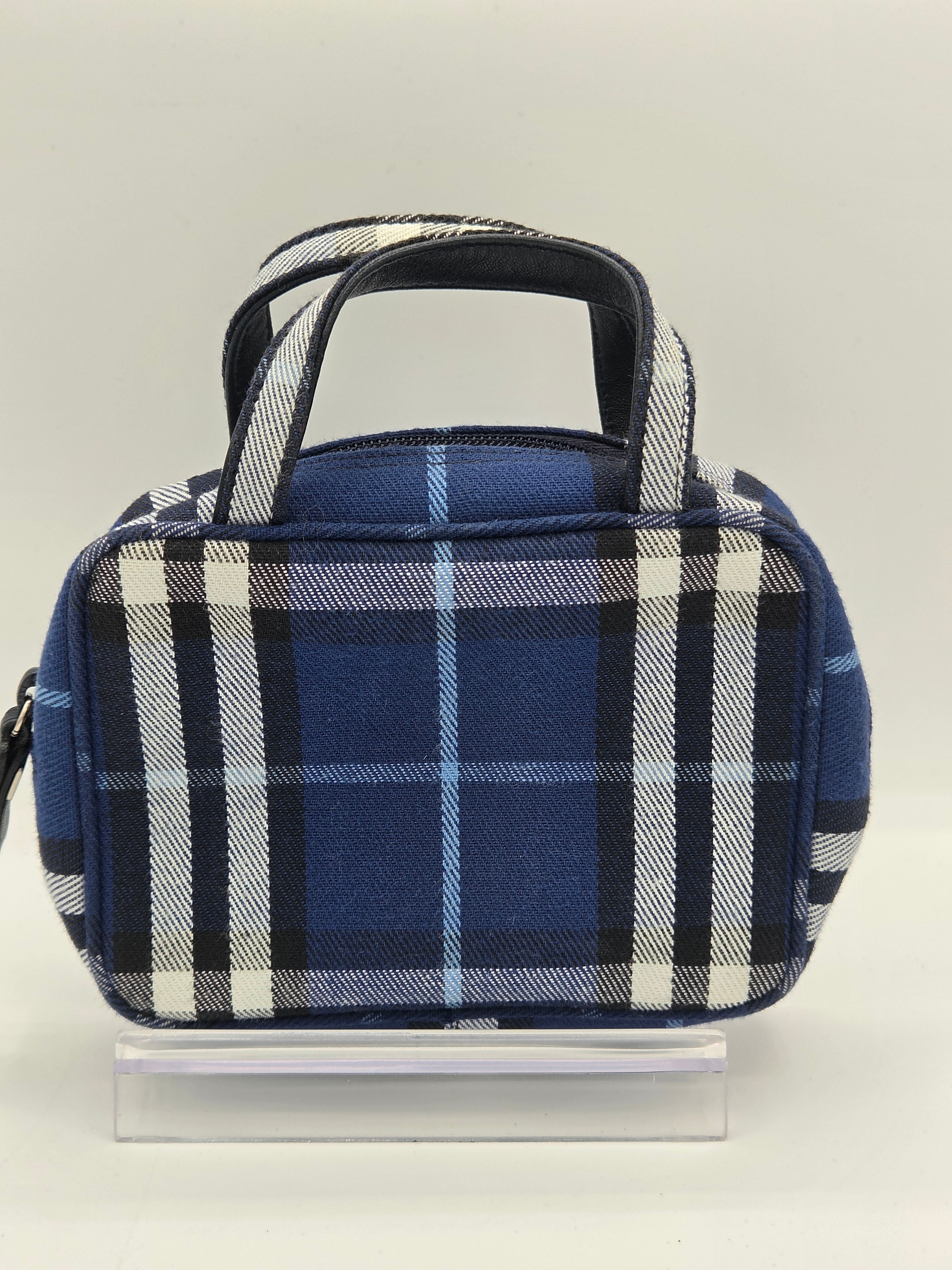 A small blue plaid lunch bag with a top handle, shown from a side angle against a plain light background.