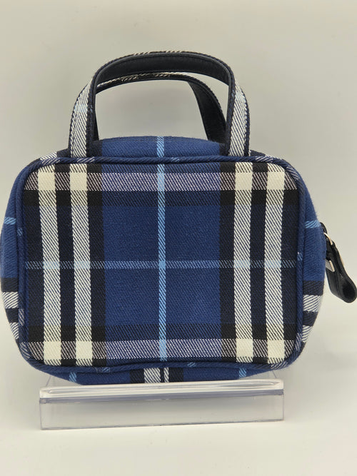 A small blue plaid zippered pouch with a top handle, shown from above on a light neutral background next to a clear plastic ruler for scale.