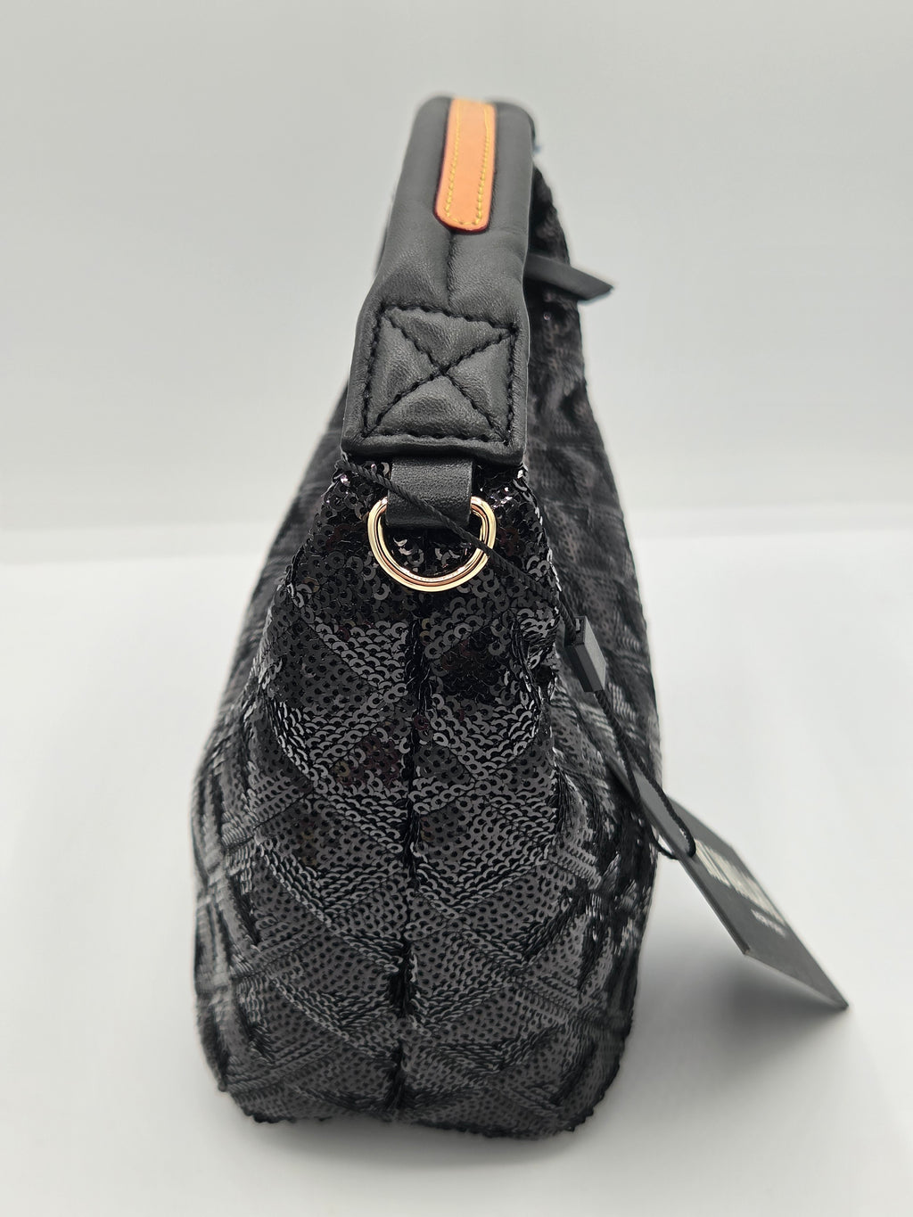 A black quilted leather shoulder bag with a gold-tone metal ring and a small orange accent tab on the handle, shown against a light gray background with a product tag attached.