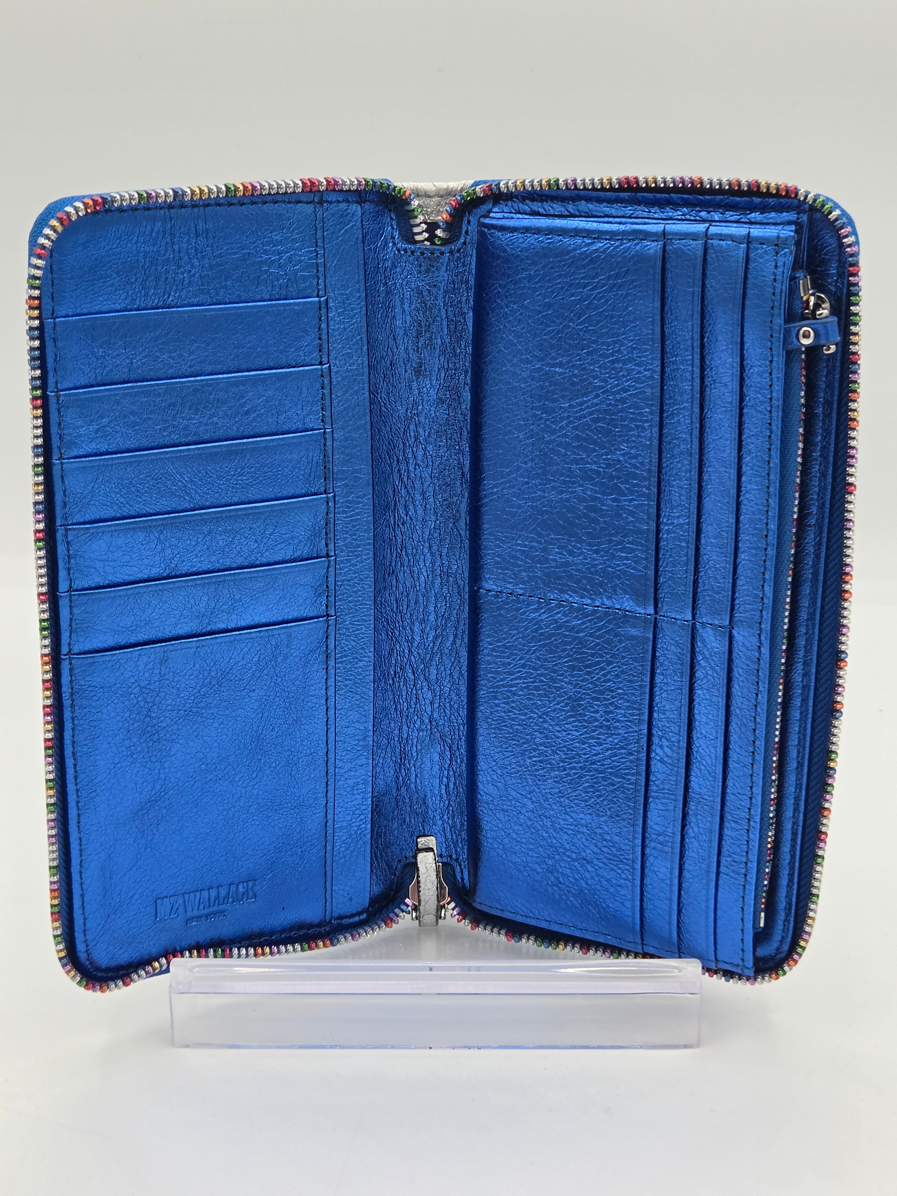 An open blue leather zip-around wallet with multiple card slots and a striped multicolor trim, displayed on a clear acrylic stand against a light gray background.