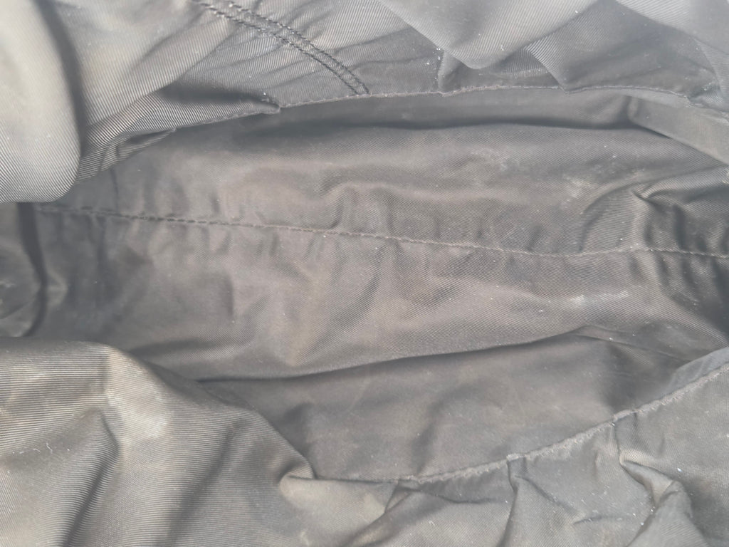 Close-up of a dark gray fabric surface with visible stitching and a slightly wrinkled texture.