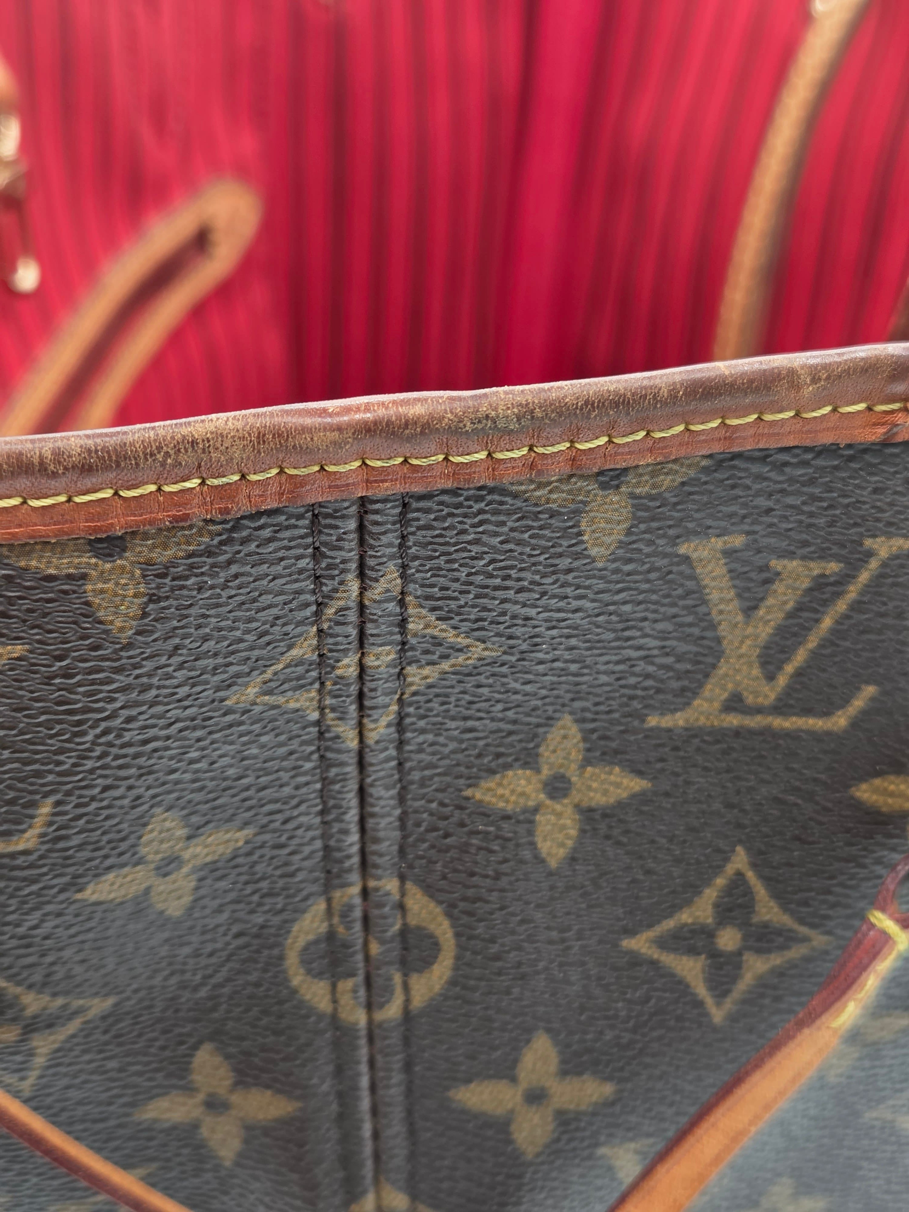 Close-up of a Louis Vuitton monogram canvas bag with dark brown coated canvas, tan monogram print, and brown leather trim with gold stitching.