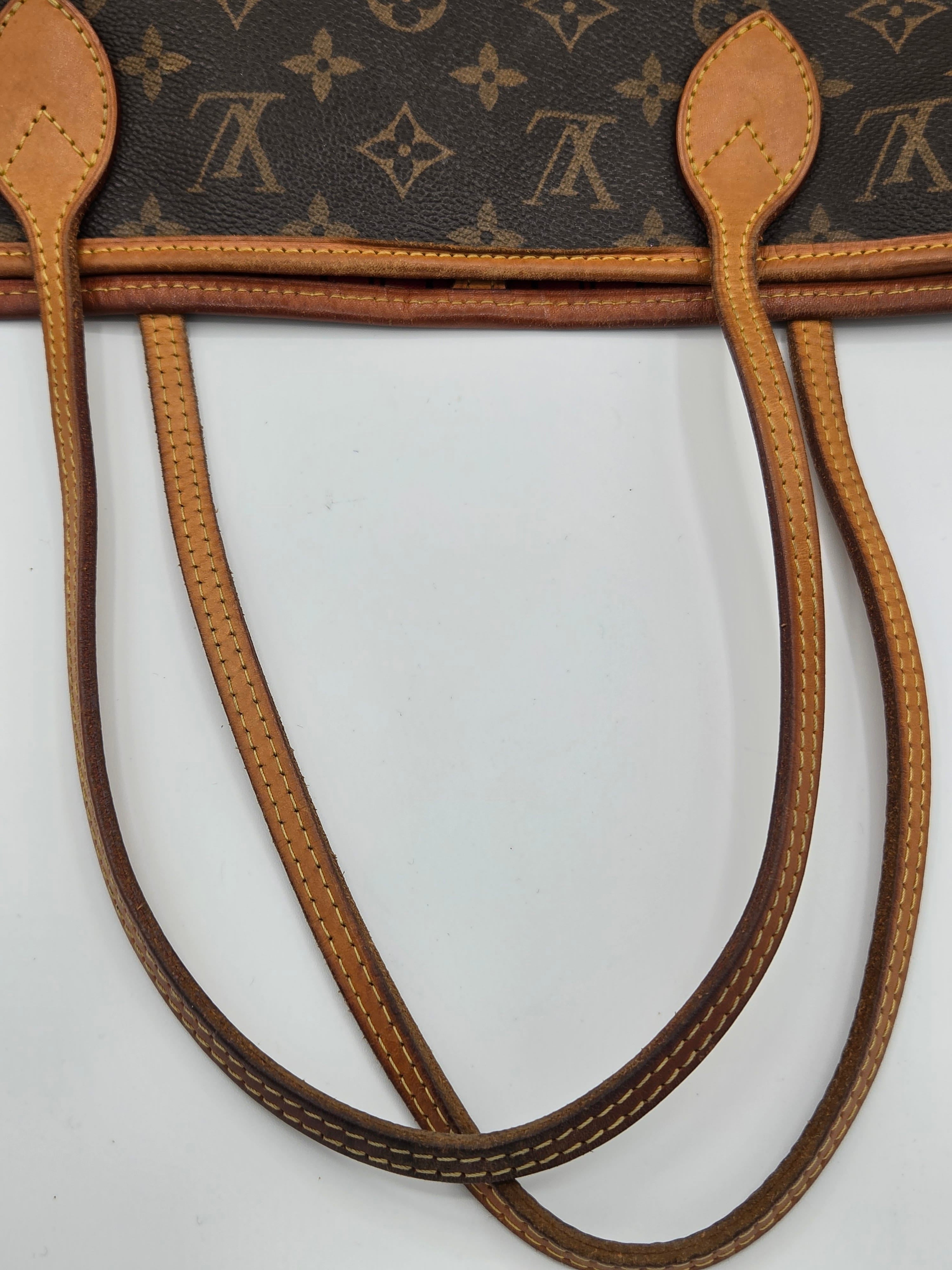 Close-up of a Louis Vuitton monogram tote bag showing the dark brown coated canvas with tan monogram print and matching tan leather handles on a white background.
