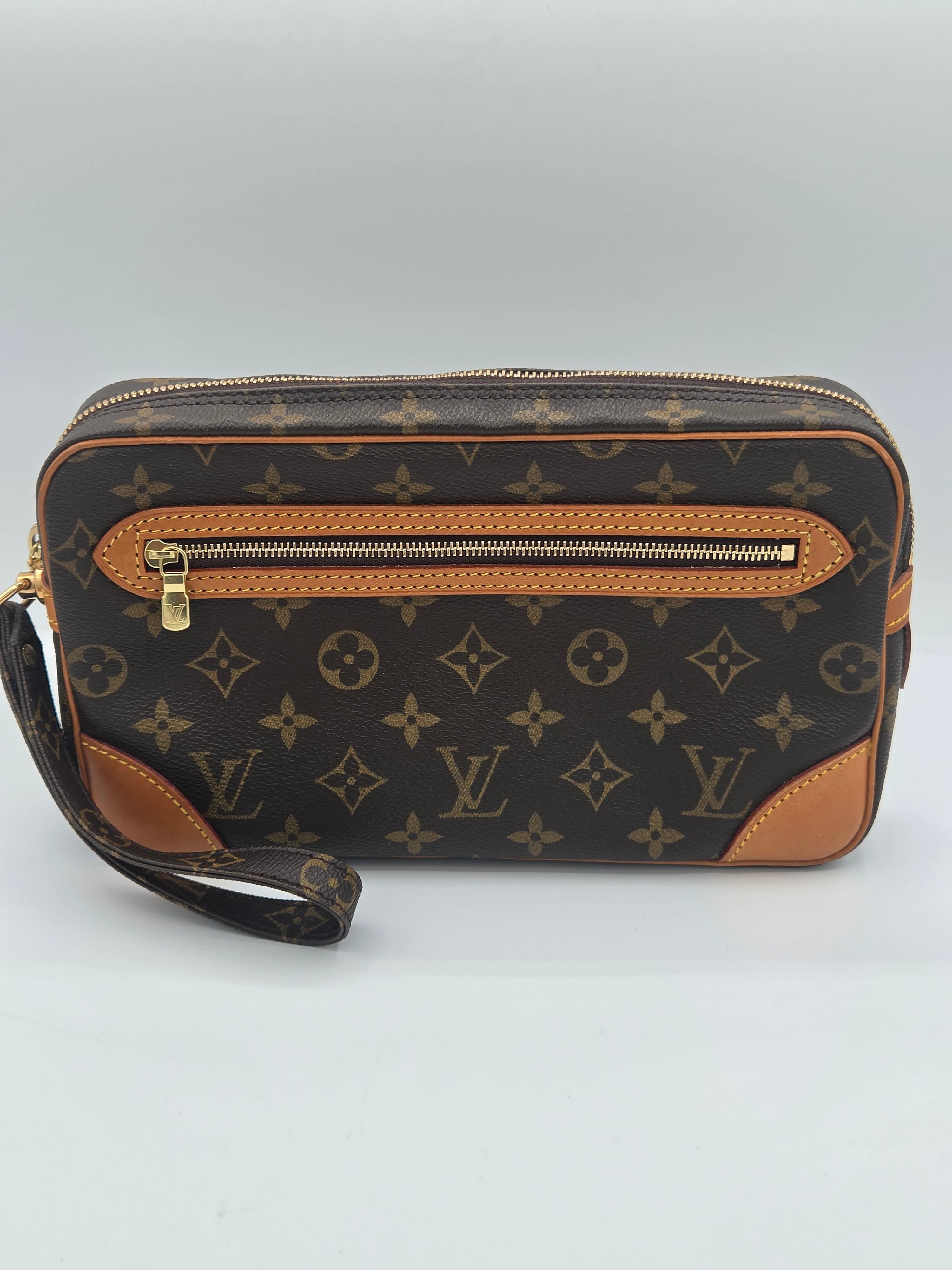 Louis Vuitton monogram canvas pouch with tan leather trim and a wristlet strap, photographed on a light gray background.