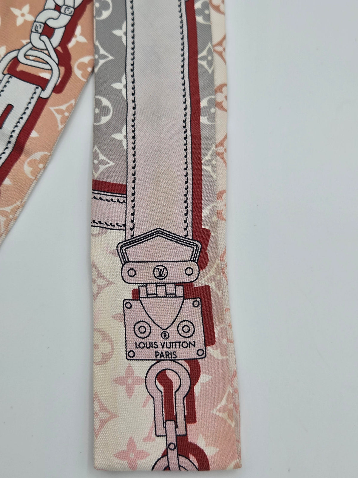 A Louis Vuitton silk scarf featuring the iconic 'Pigalle' padlock motif from the LV monogram collection, in beige, dusty pink, and dark red with silver-gray details.