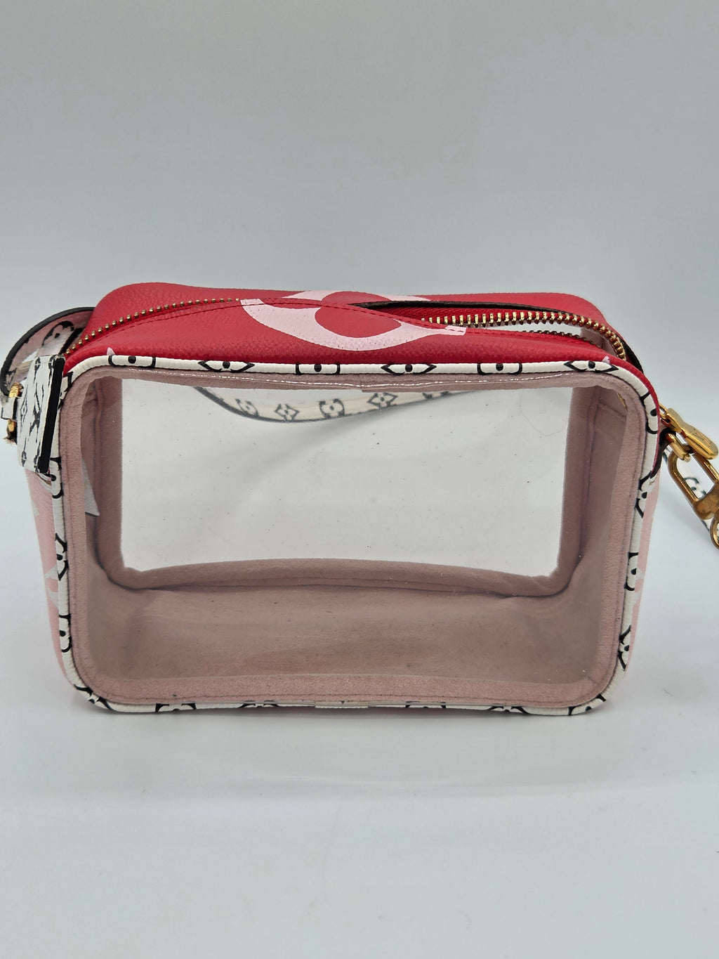 A small rectangular cosmetic pouch with a clear front window, a red top flap, and a black-and-white patterned body, shown on a light gray background.