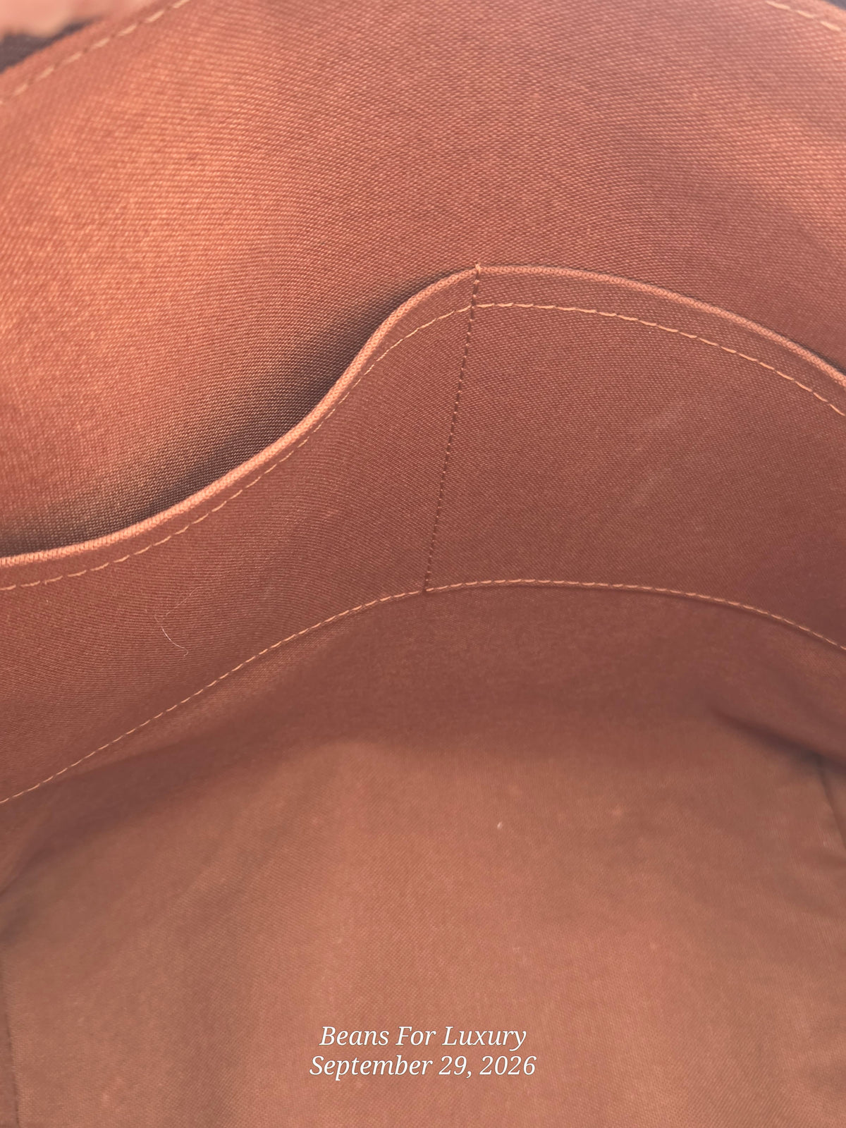 Close-up of a brown fabric interior with stitched pocket or lining detail, photographed tightly with a small white watermark reading Beans For Luxury and September 29, 2026 in the lower right.