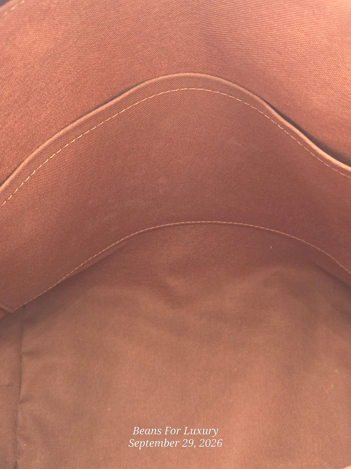 Close-up of the interior lining of a brown leather or faux-leather bag, showing stitched curved paneling and a suede-like brown surface. Small white text at the bottom reads 'Beans For Luxury September 29, 2026'.