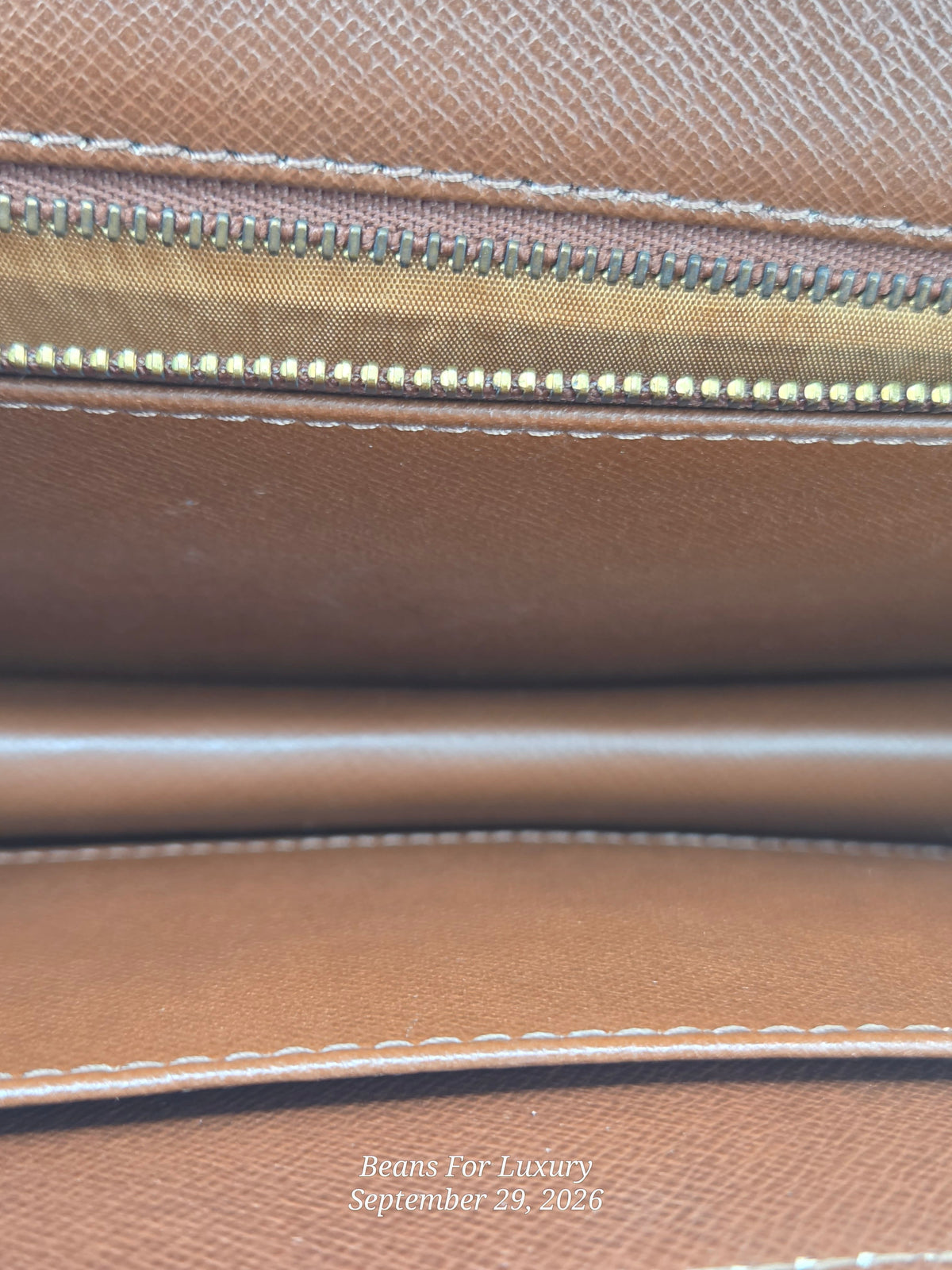 Close-up of a brown textured leather interior with a gold-toned zipper and white stitching. A small watermark at the bottom reads Beans For Luxury September 29, 2026.