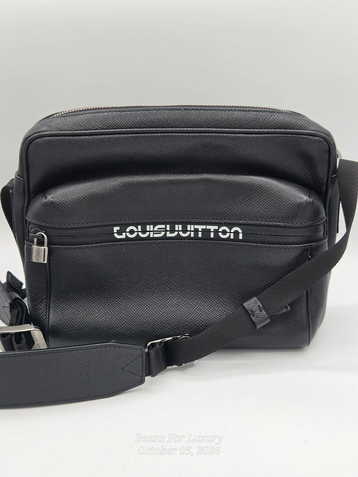 A black Louis Vuitton leather crossbody bag with a textured grain finish, featuring the brand name in white on the front pocket and a matching black shoulder strap.