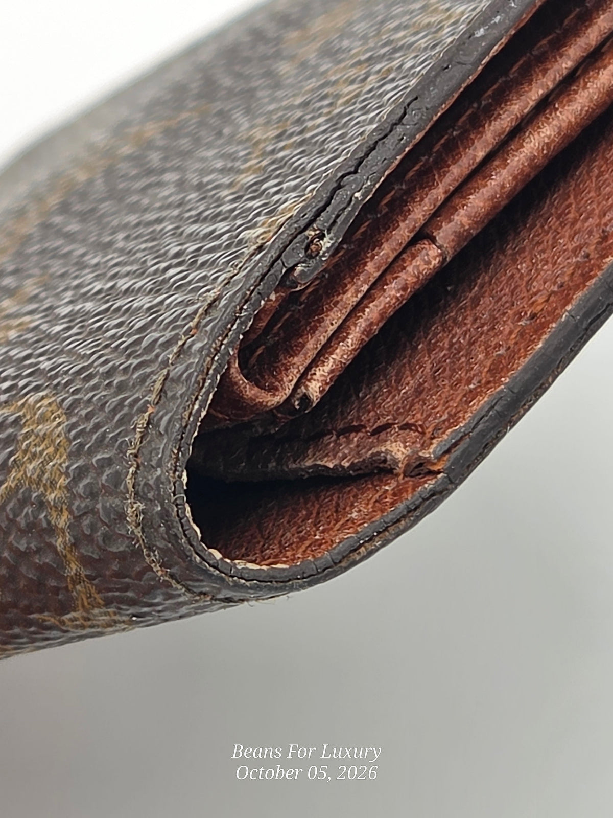 Close-up of a brown textured leather wallet corner showing the interior fold and worn edge, with a small watermark reading Beans For Luxury at the bottom.