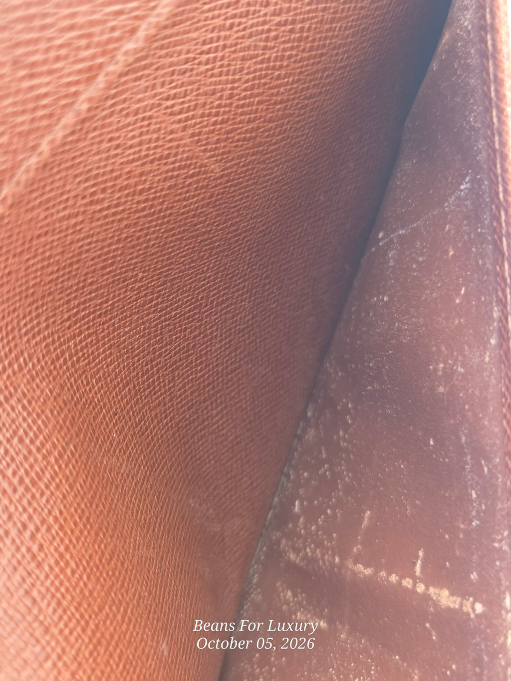 Close-up of a brown textured leather interior, showing a pebbled or saffiano-like grain on one side and a smoother worn inner panel on the other, with a small watermark reading 'Beans For Luxury October 05, 2026' near the bottom.