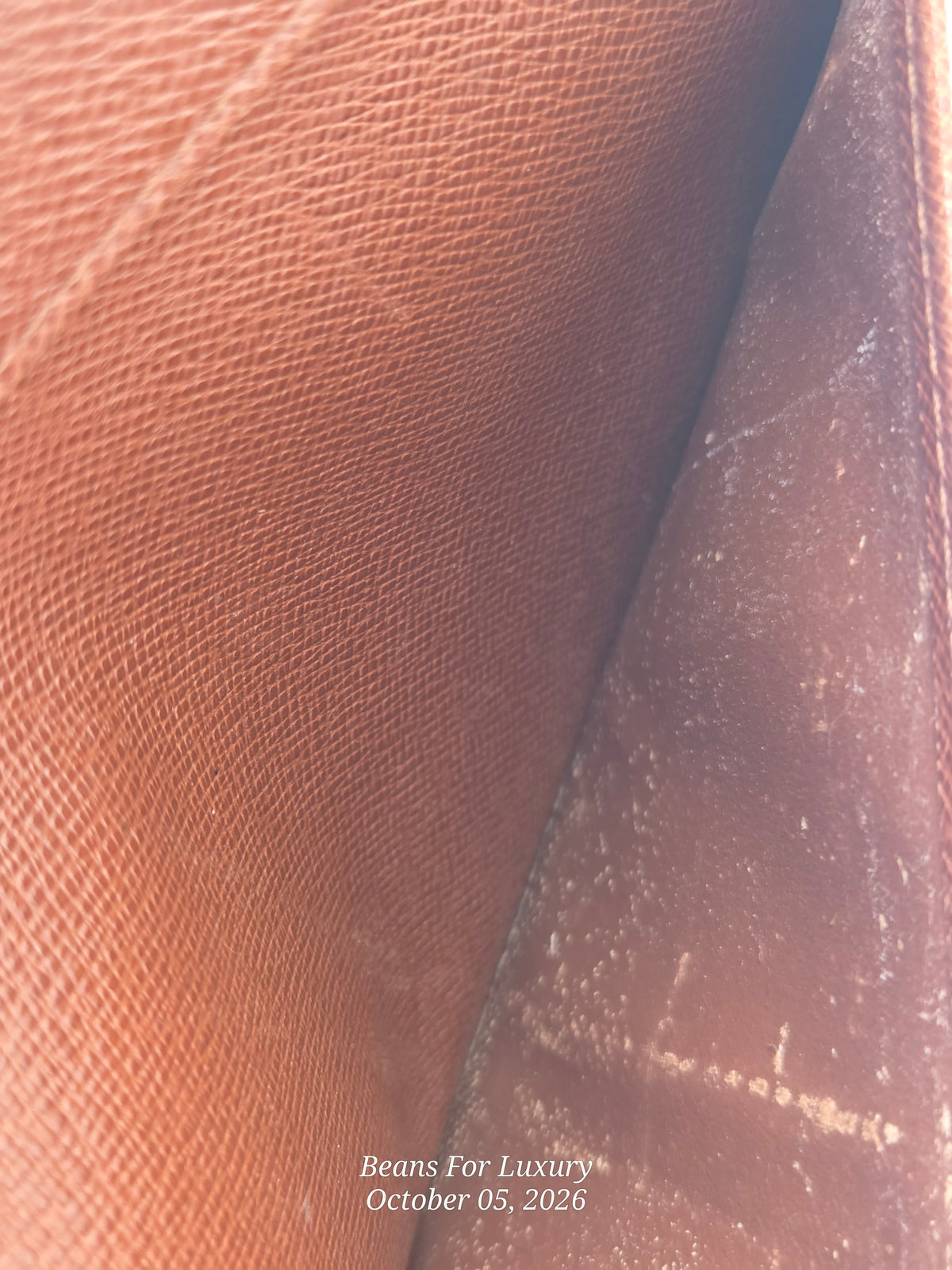 Close-up of a brown textured leather interior, showing a pebbled or saffiano-like grain on one side and a smoother worn inner panel on the other, with a small watermark reading 'Beans For Luxury October 05, 2026' near the bottom.