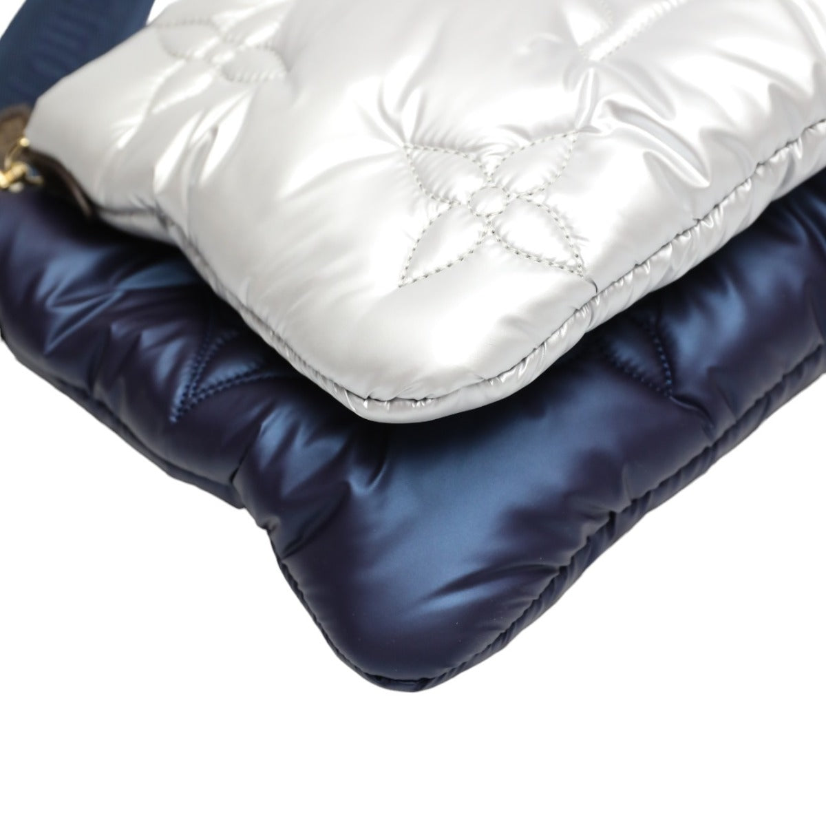 Close-up of a white and navy blue quilted jacket on a white background