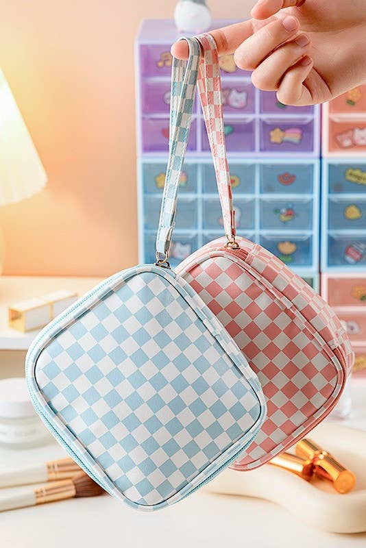 Checkered makeup bag with a strap held by a hand against a colorful background