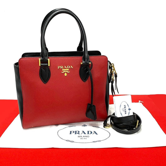 Red Prada handbag with black accents on a white background