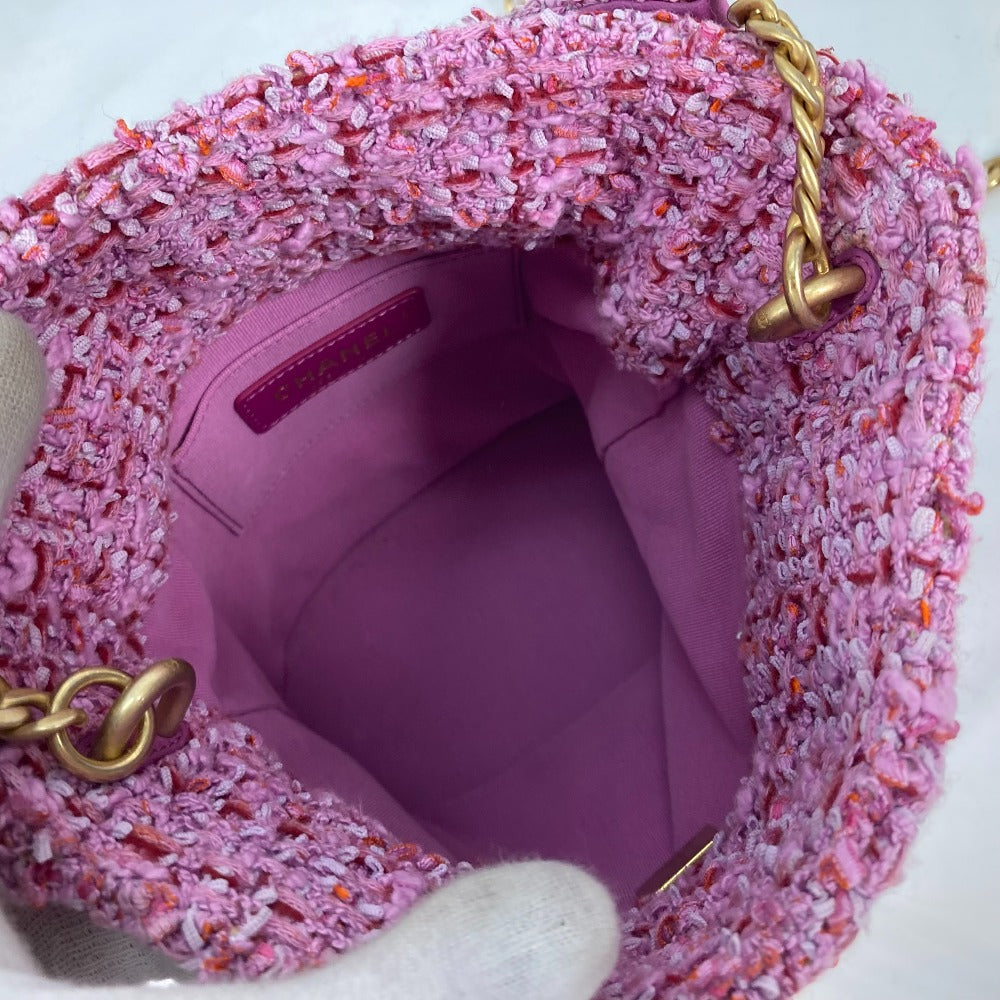 Pink textured handbag with gold chain handle on a white background