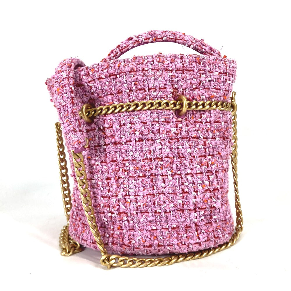Pink textured handbag with gold chain strap on a white background