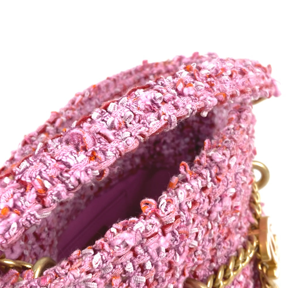 Close-up of a pink textured handbag with gold chain strap on a white background