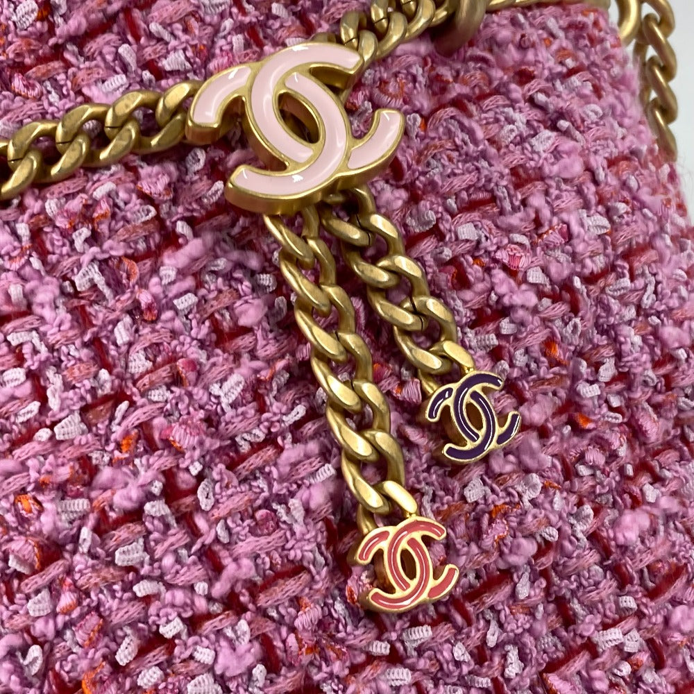 Gold chain with Chanel logo on a pink textured background