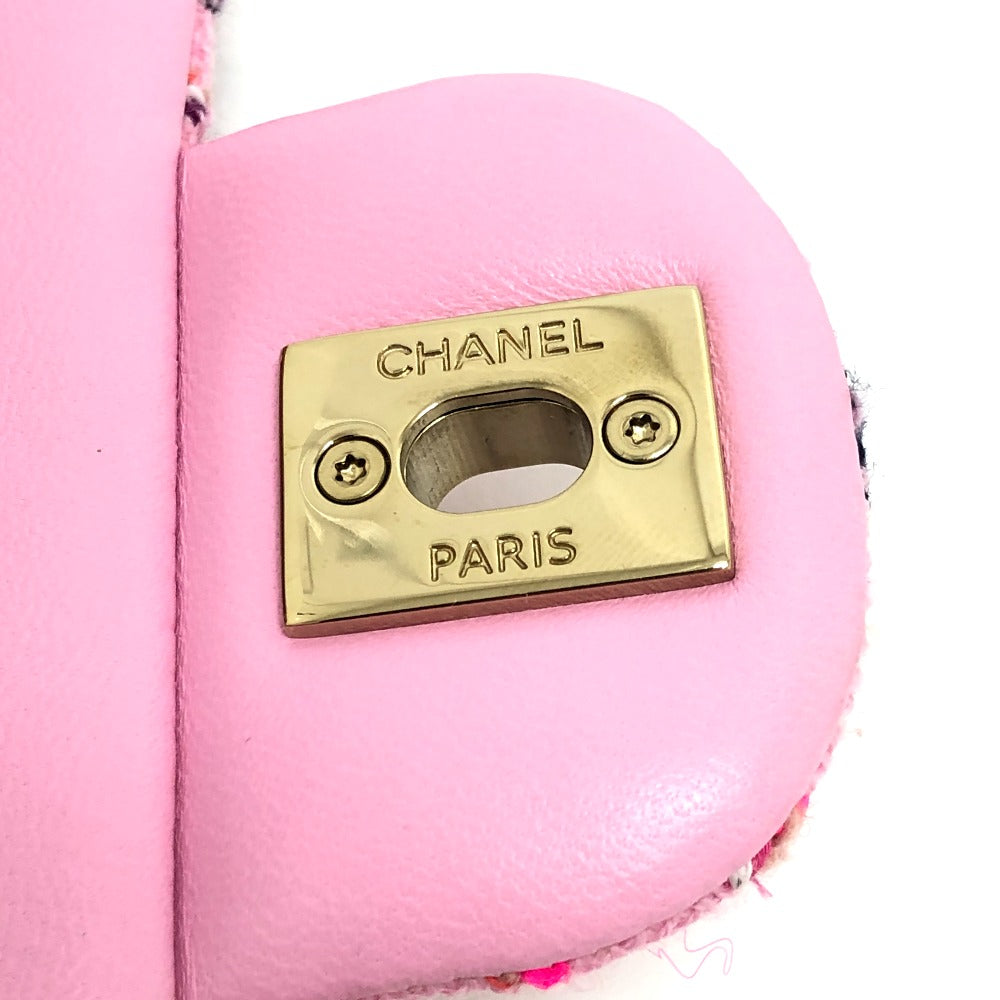 Close-up of a pink Chanel handbag with gold logo on a white background