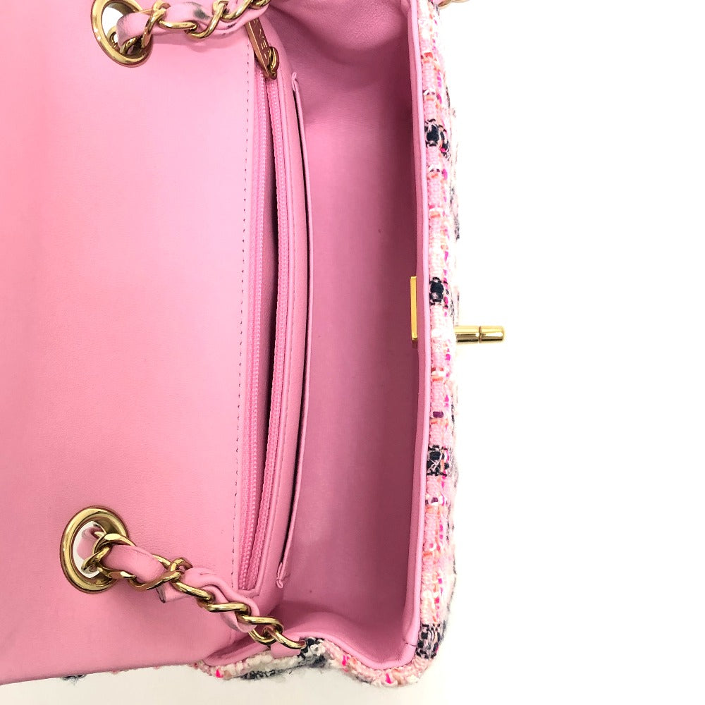 Close-up of a pink handbag with floral pattern and gold chain detail.