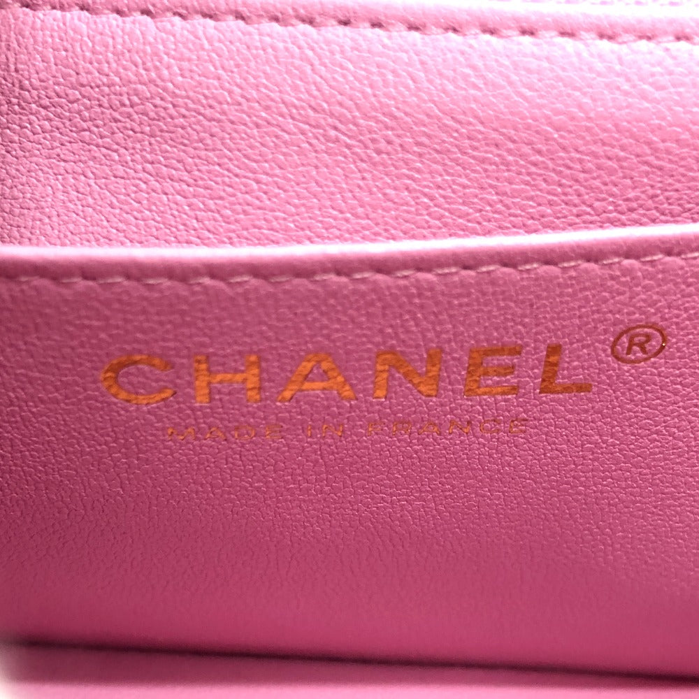 Close-up of a pink Chanel wallet with gold logo.