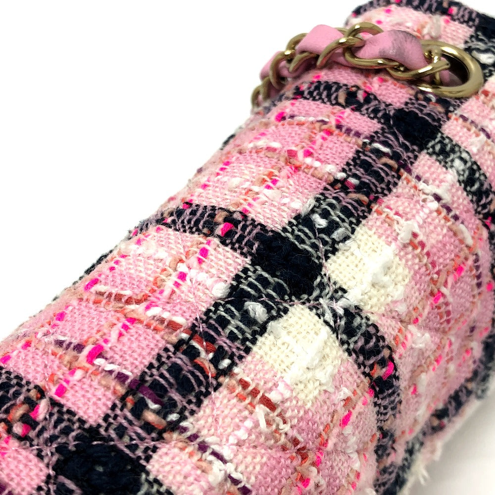 Close-up of a pink and black plaid fabric with a gold ring on a white background